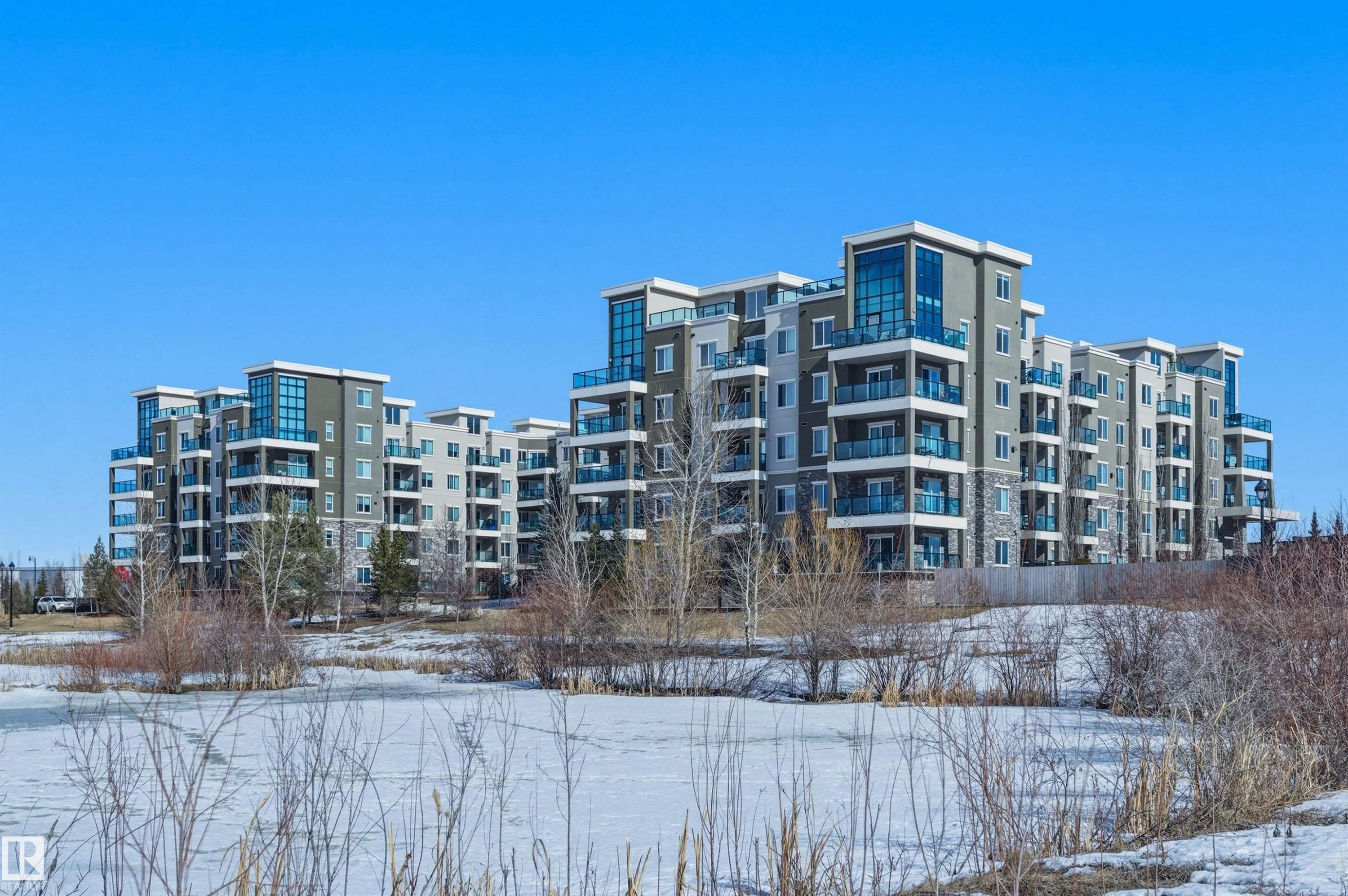 Snow covered property with a view of apartment building / complex - 106 1238 Windermere Way, Edmonton, AB - Outdoor With Facade