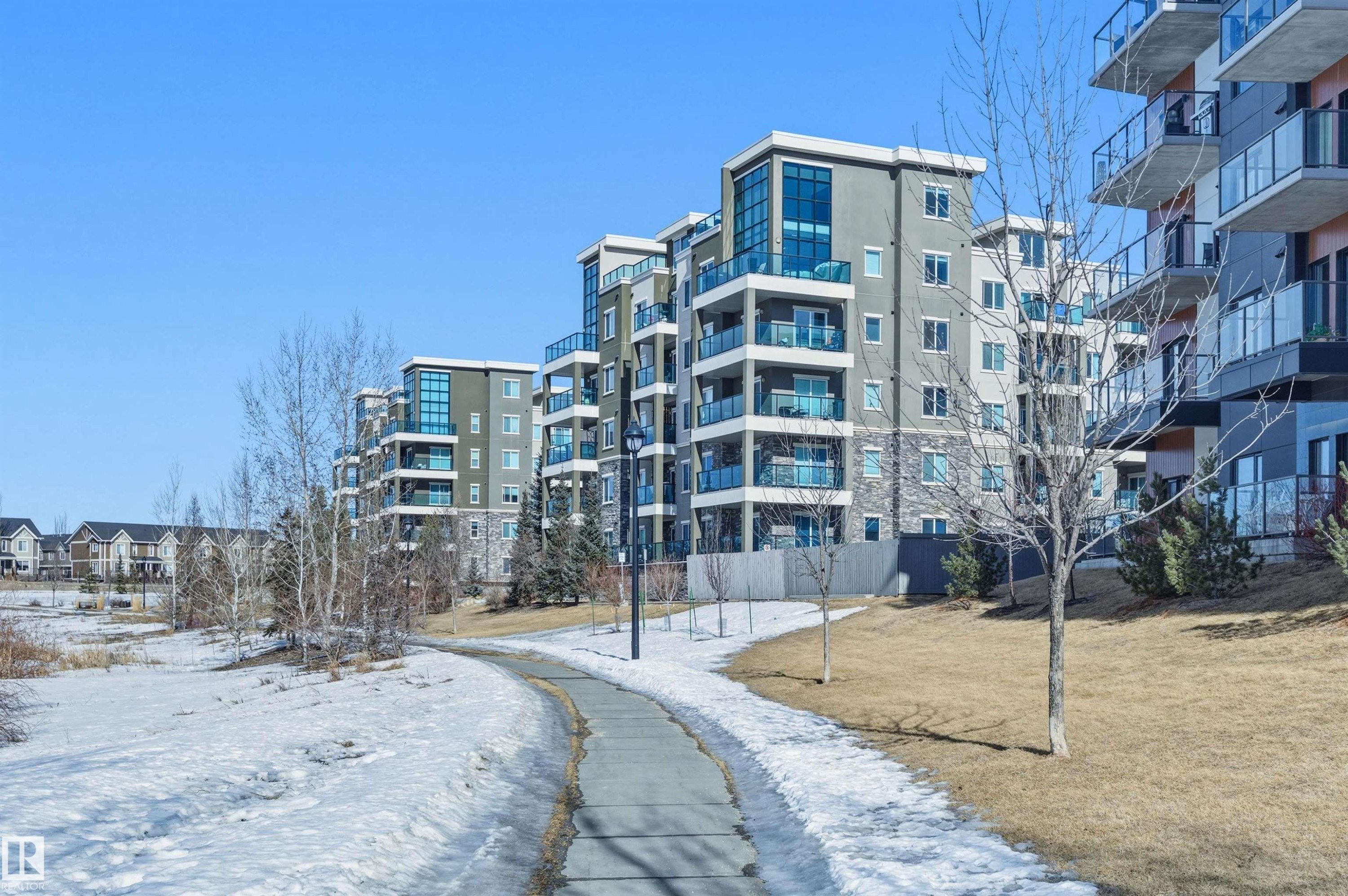 Snow covered property with a view of apartment building / complex - 106 1238 Windermere Way, Edmonton, AB - Outdoor With Balcony With Facade