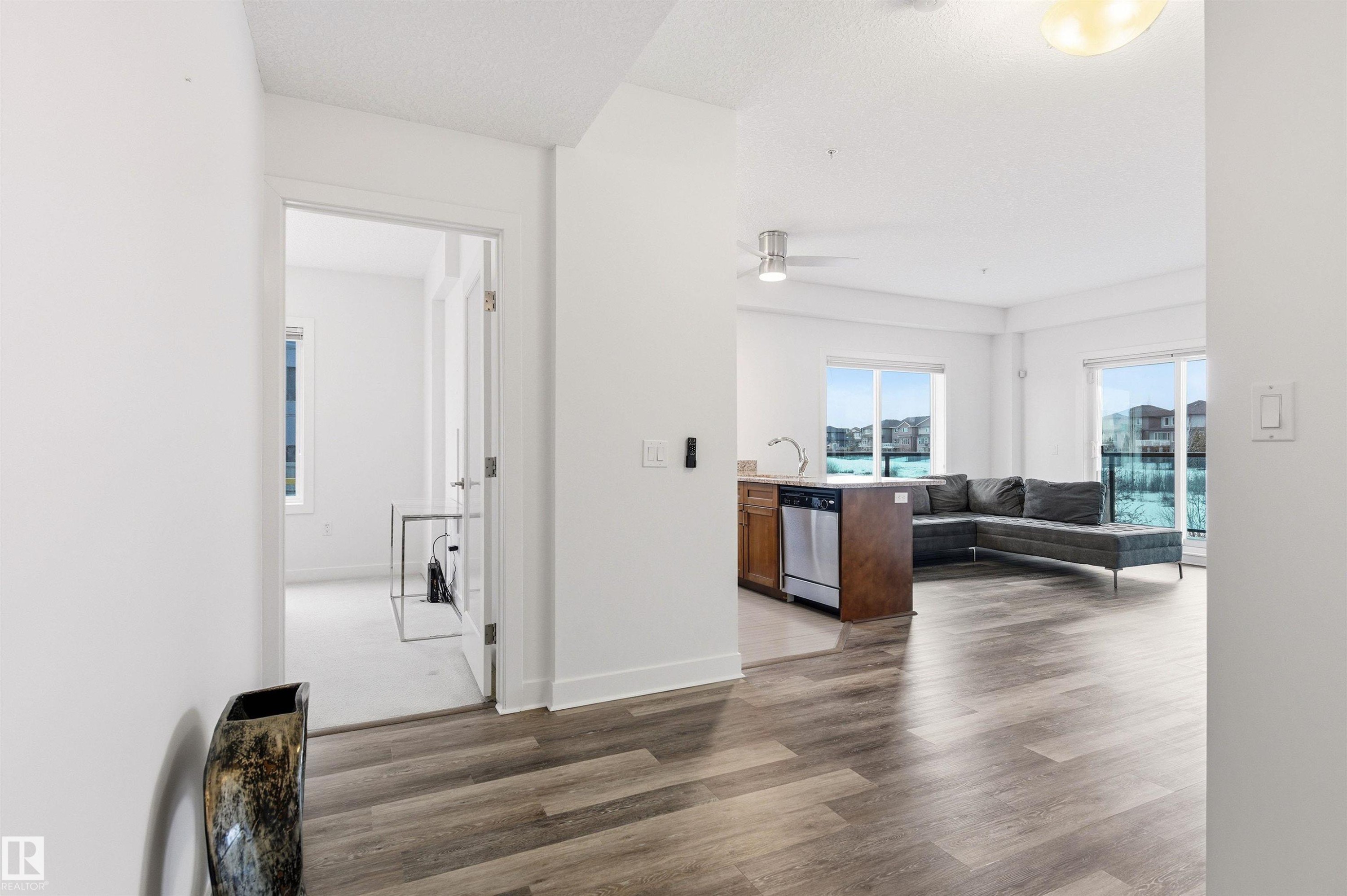 Hall featuring dark wood-style floors and baseboards - 106 1238 Windermere Way, Edmonton, AB - Indoor Photo Showing Other Room