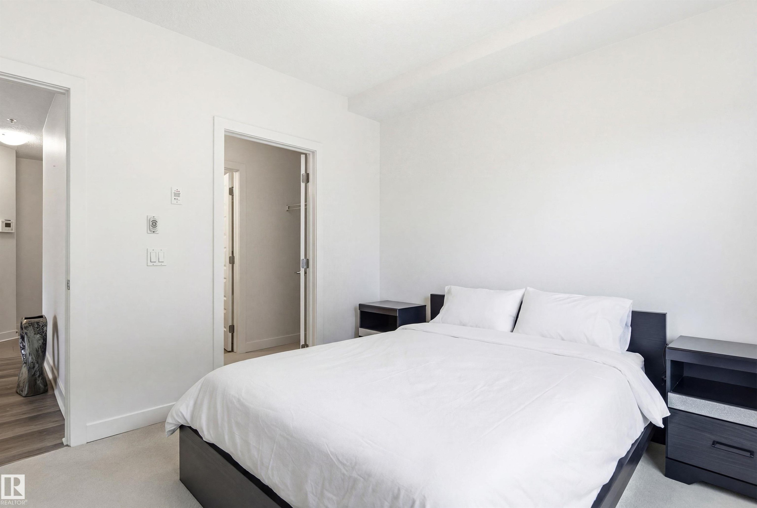 Bedroom featuring baseboards and light carpet - 106 1238 Windermere Way, Edmonton, AB - Indoor Photo Showing Bedroom