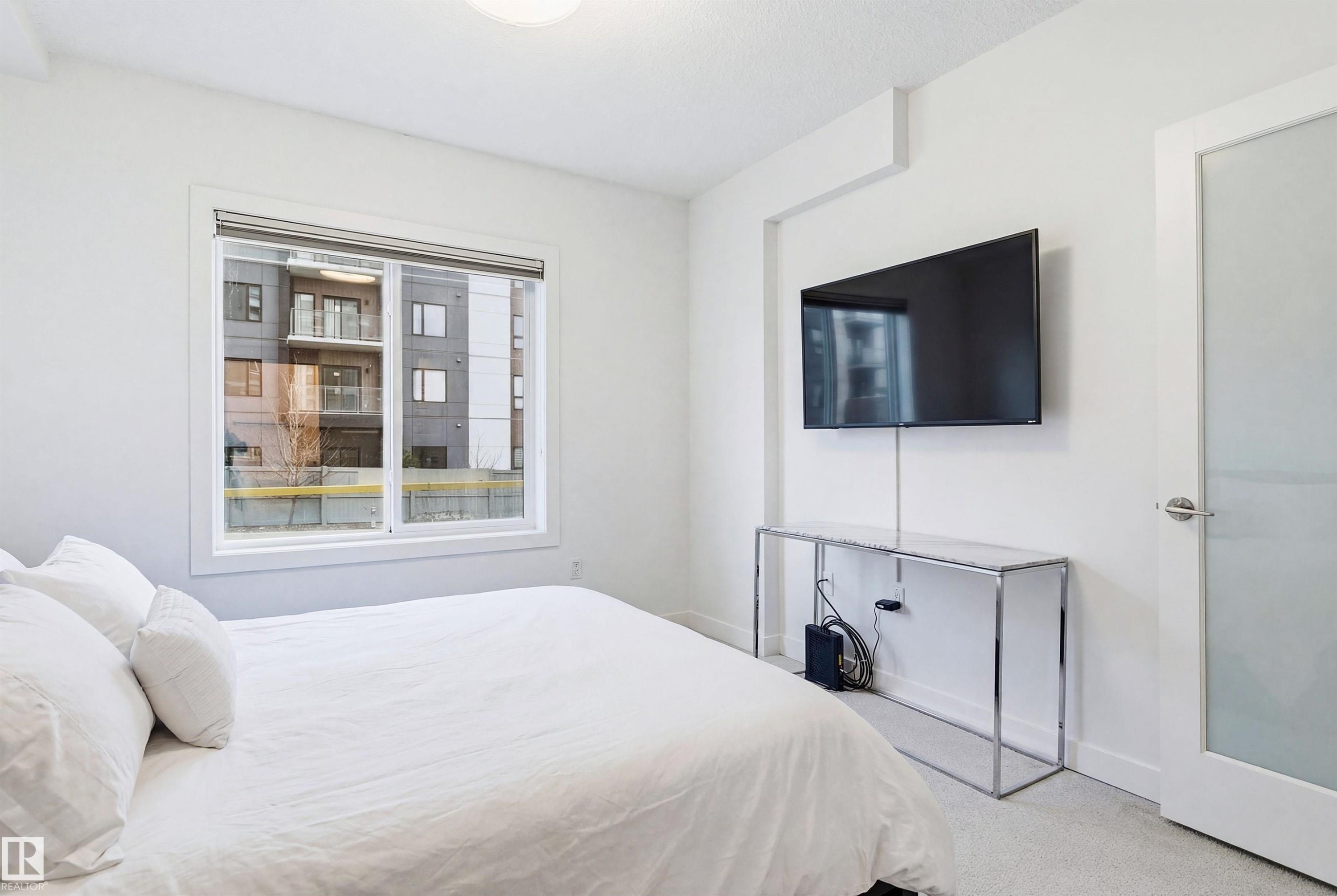 Bedroom featuring light colored carpet and baseboards - 106 1238 Windermere Way, Edmonton, AB - Indoor Photo Showing Bedroom