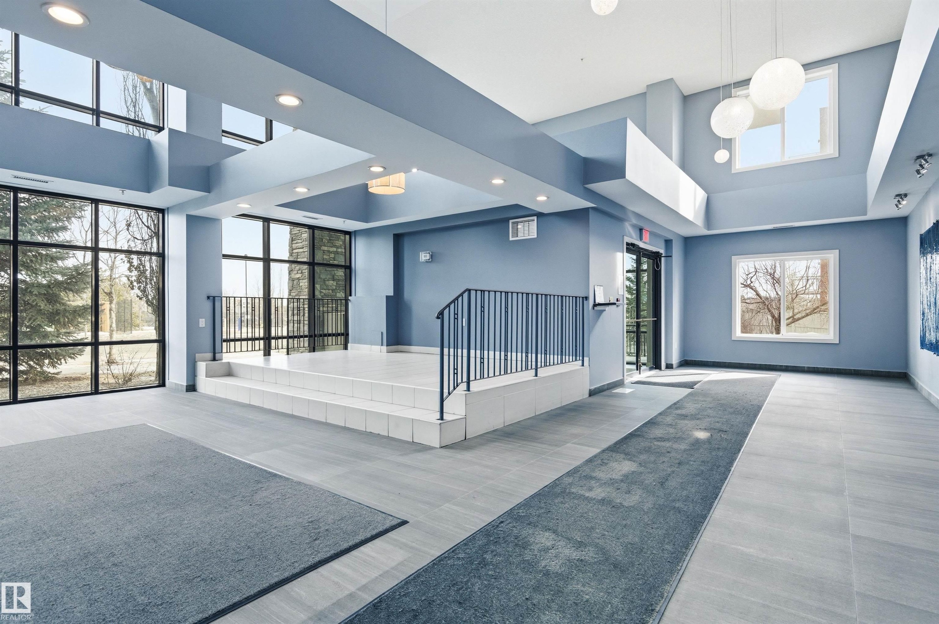 Building lobby featuring a high ceiling and recessed lighting - 106 1238 Windermere Way, Edmonton, AB - Indoor Photo Showing Other Room