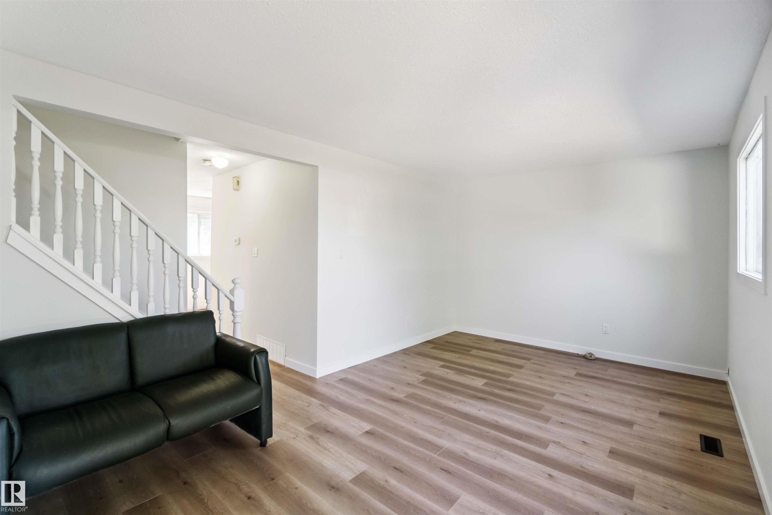 Living area with stairway and light wood-style flooring - 1096 Millbourne Road E, Edmonton, AB - Indoor