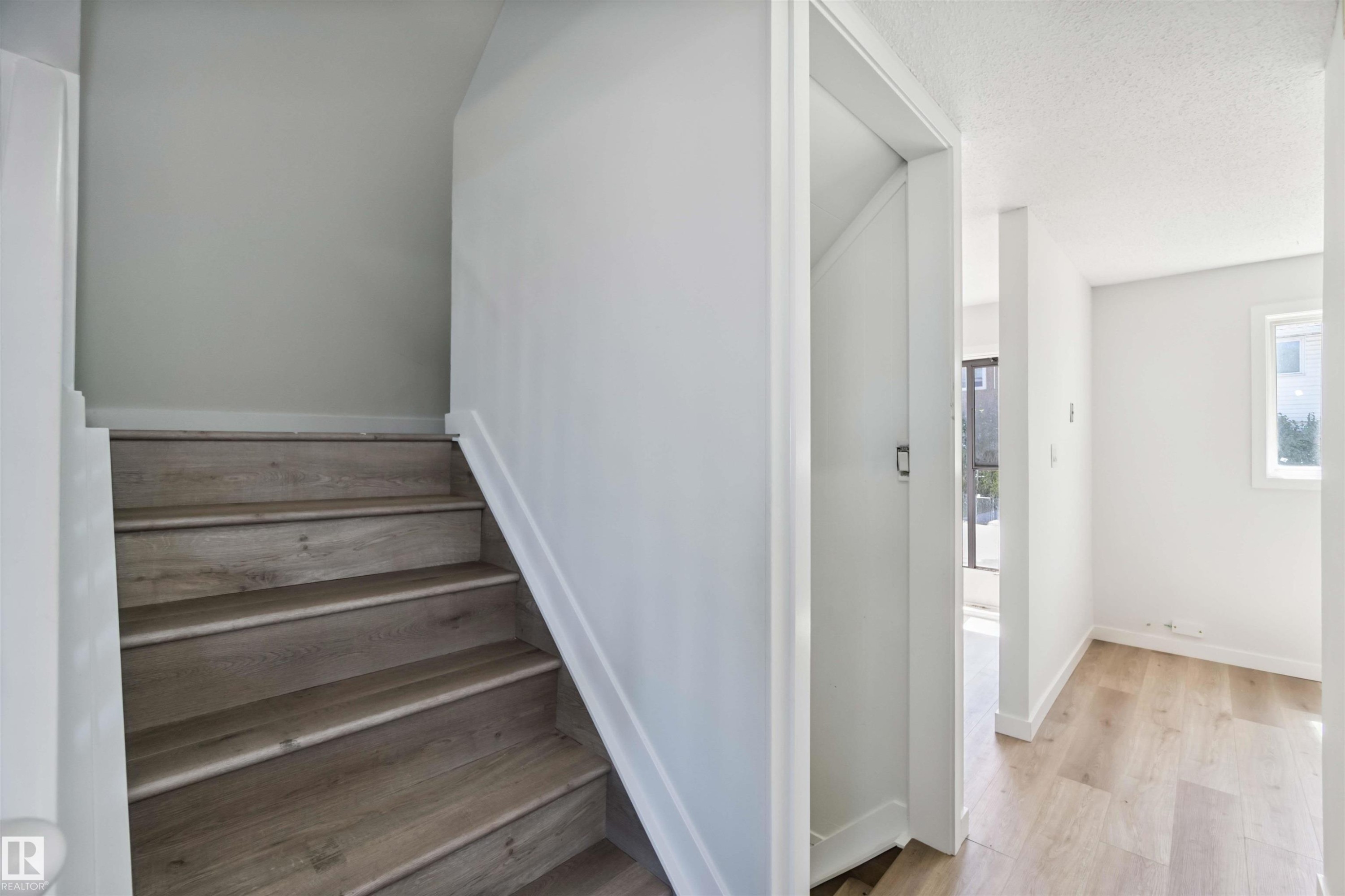 Stairway featuring wood finished floors and a textured ceiling - 1096 Millbourne Road E, Edmonton, AB - Indoor Photo Showing Other Room