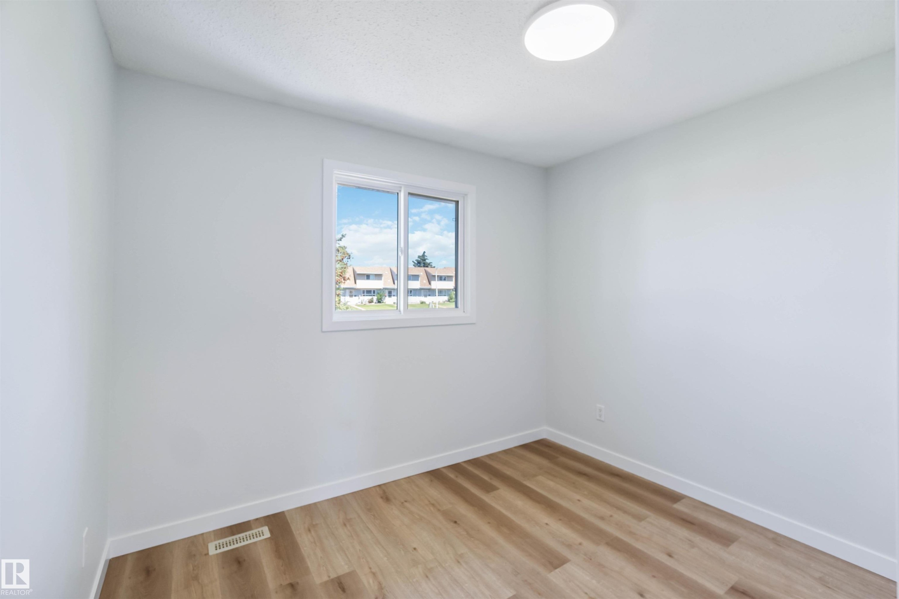 Empty room featuring baseboards and light wood-style flooring - 1096 Millbourne Road E, Edmonton, AB - Indoor Photo Showing Other Room