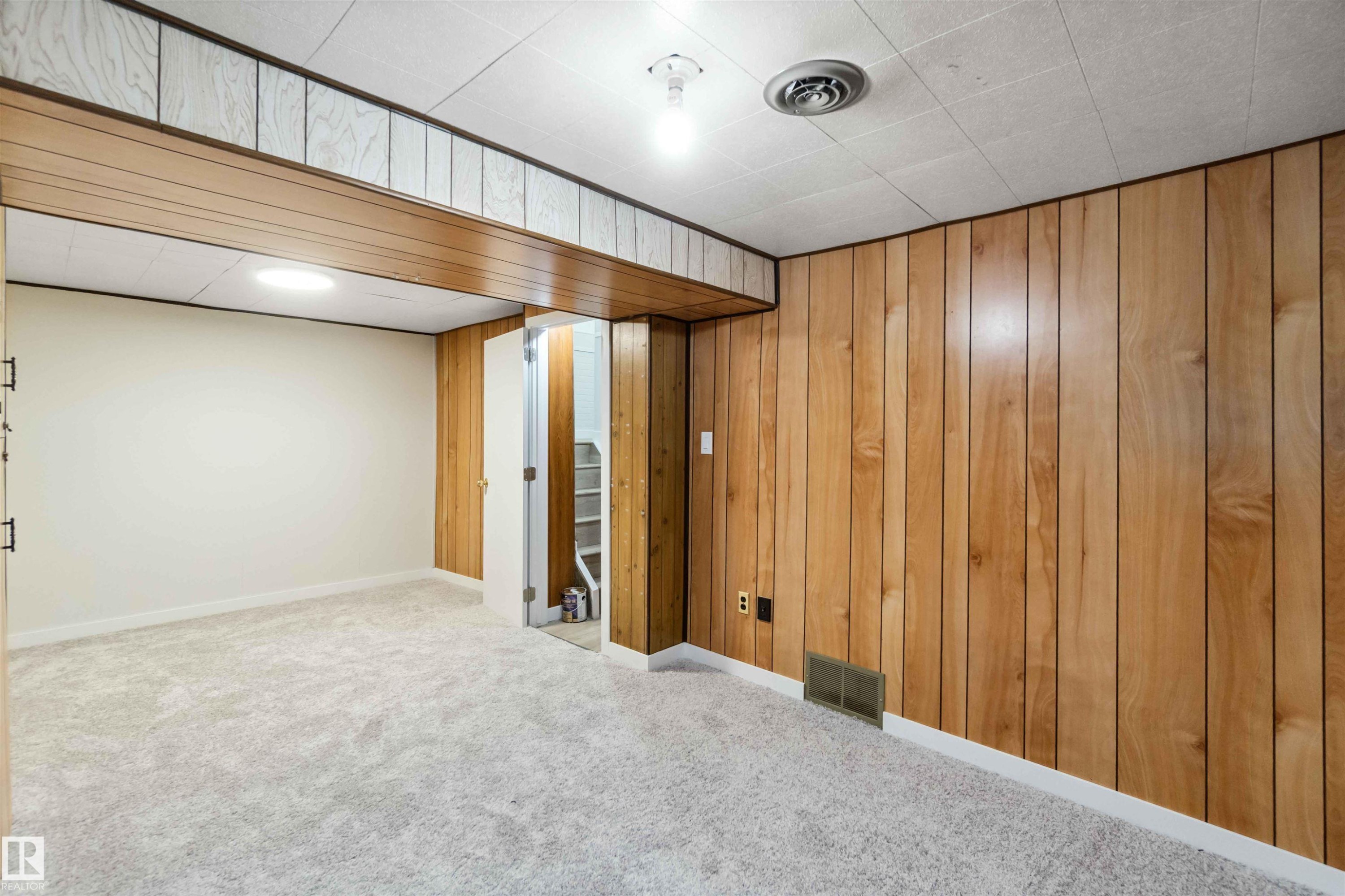 Finished basement featuring wood walls and light carpet - 1096 Millbourne Road E, Edmonton, AB - Indoor