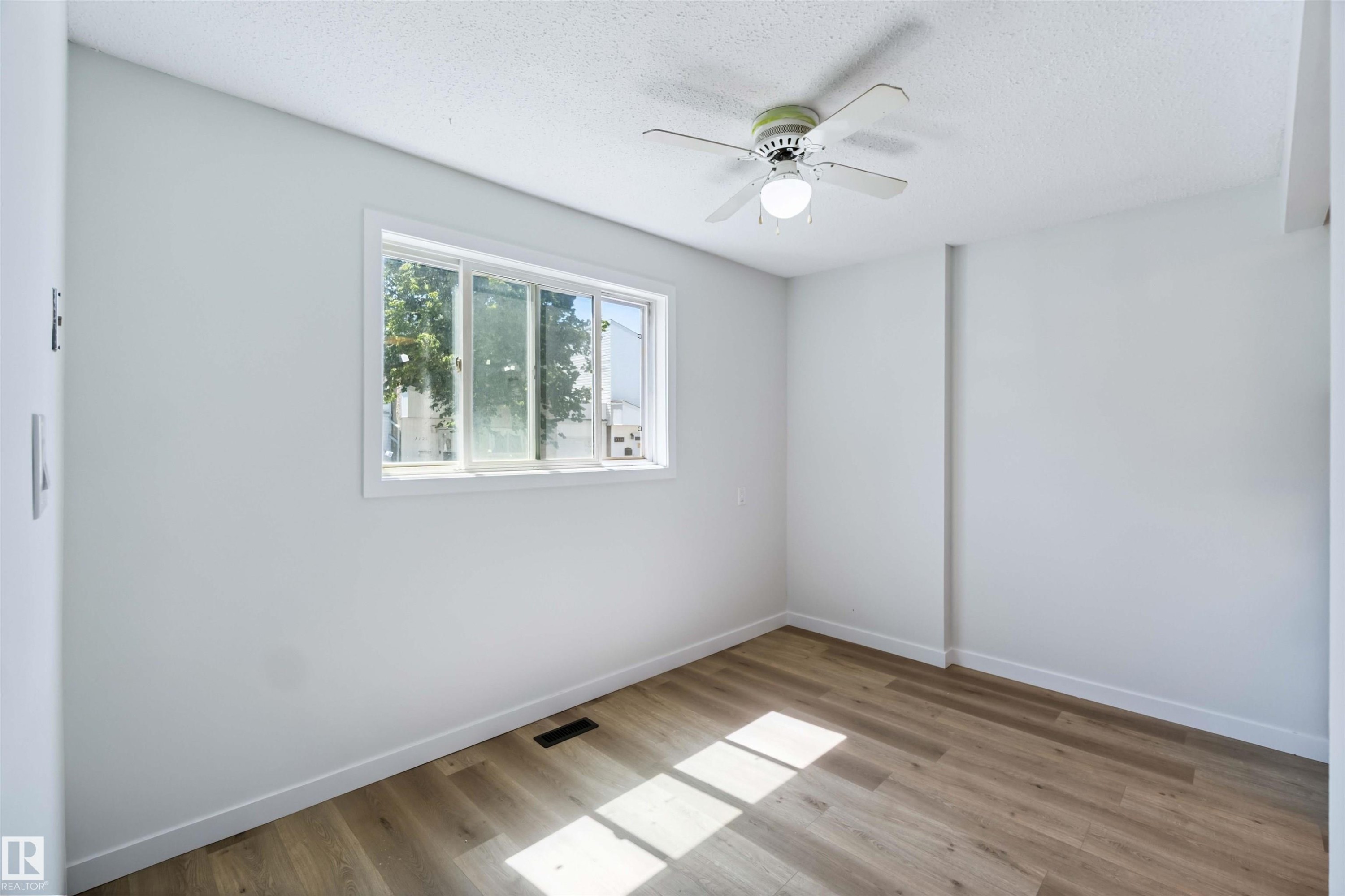 Spare room featuring ceiling fan, light wood-style floors, and a textured ceiling - 1096 Millbourne Road E, Edmonton, AB - Indoor Photo Showing Other Room