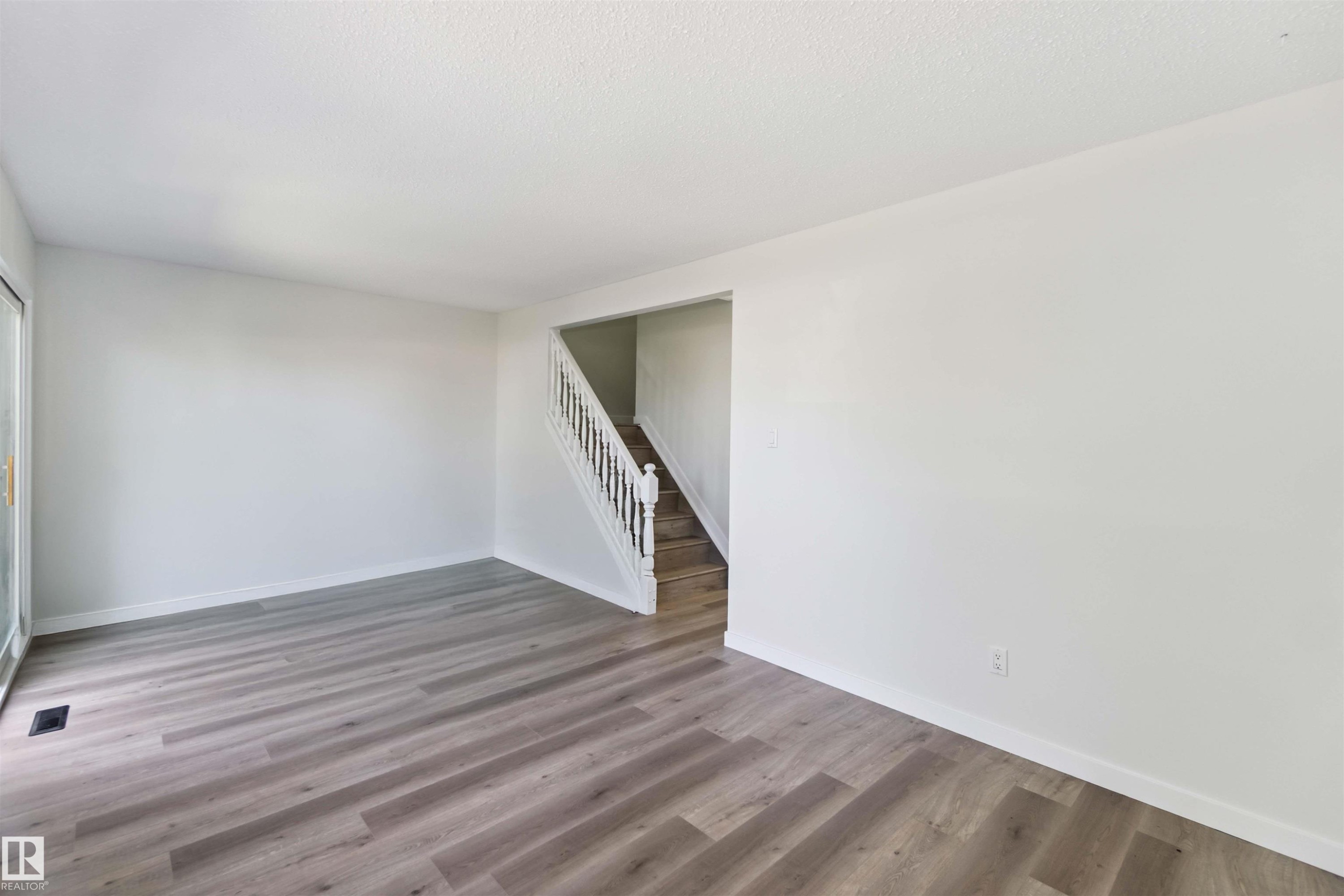 Empty room featuring stairs and wood finished floors - 1096 Millbourne Road E, Edmonton, AB - Indoor Photo Showing Other Room