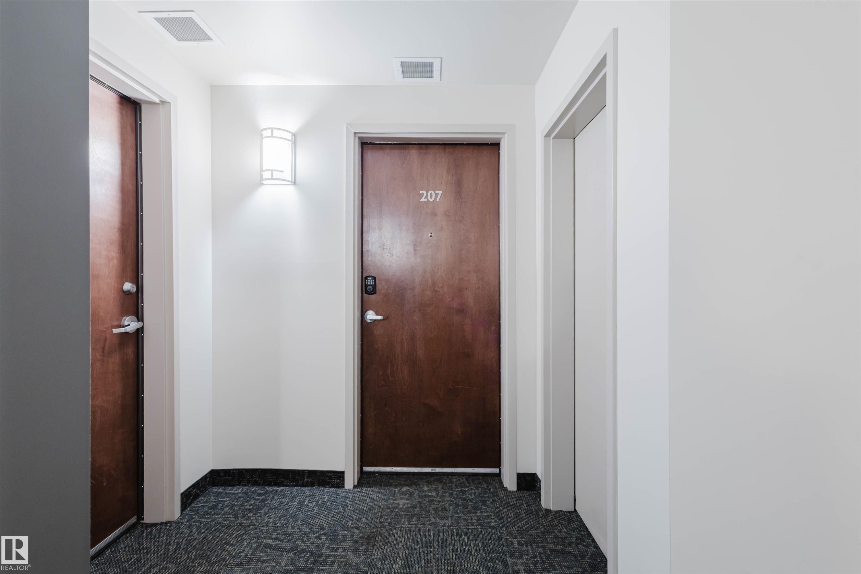 Hallway featuring baseboards and dark carpet - 207 9910 111 Street, Edmonton, AB - Indoor Photo Showing Other Room