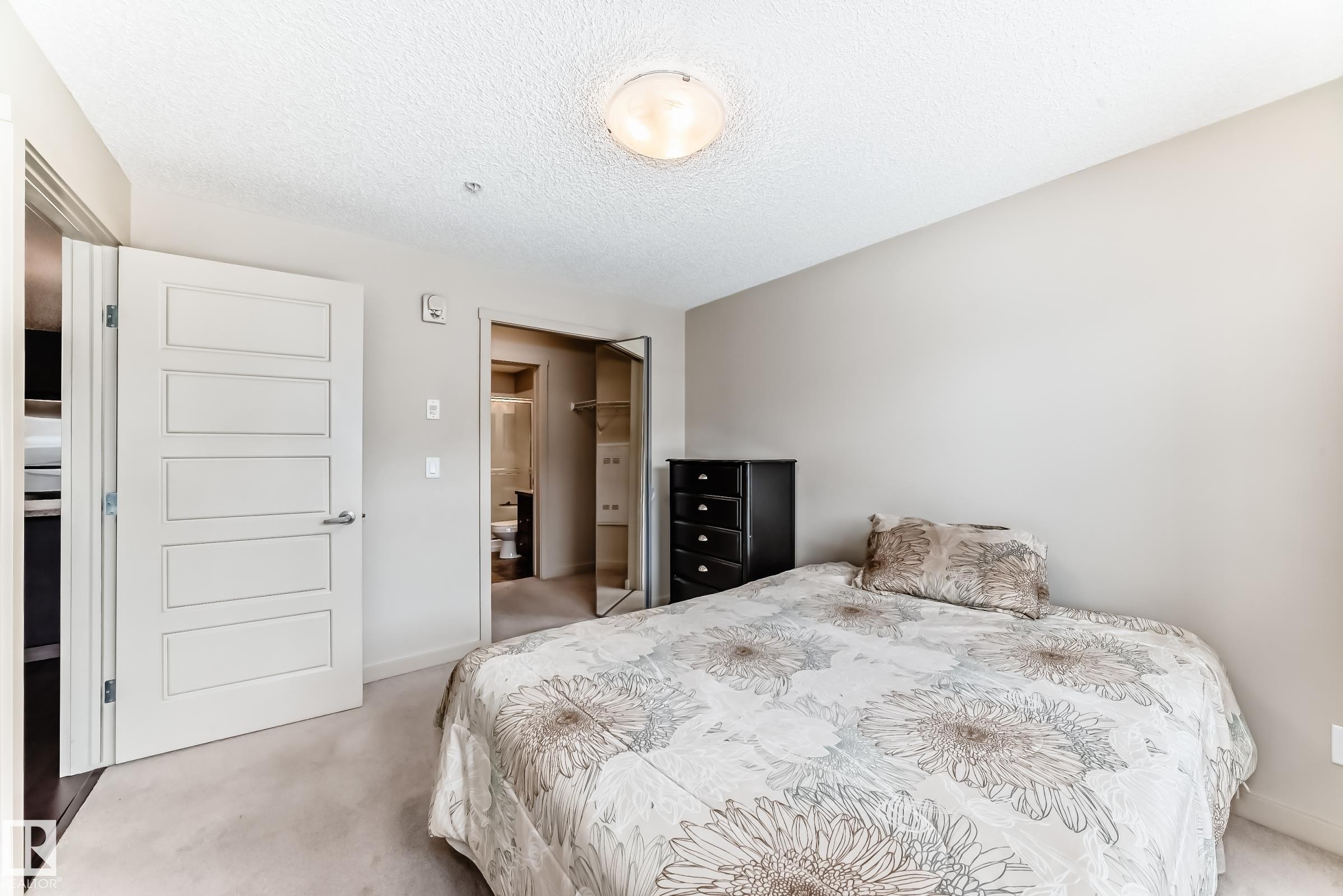 Bedroom featuring light carpet, a textured ceiling, and a closet - 229 6076 Schonsee Way, Edmonton, AB - Indoor Photo Showing Bedroom