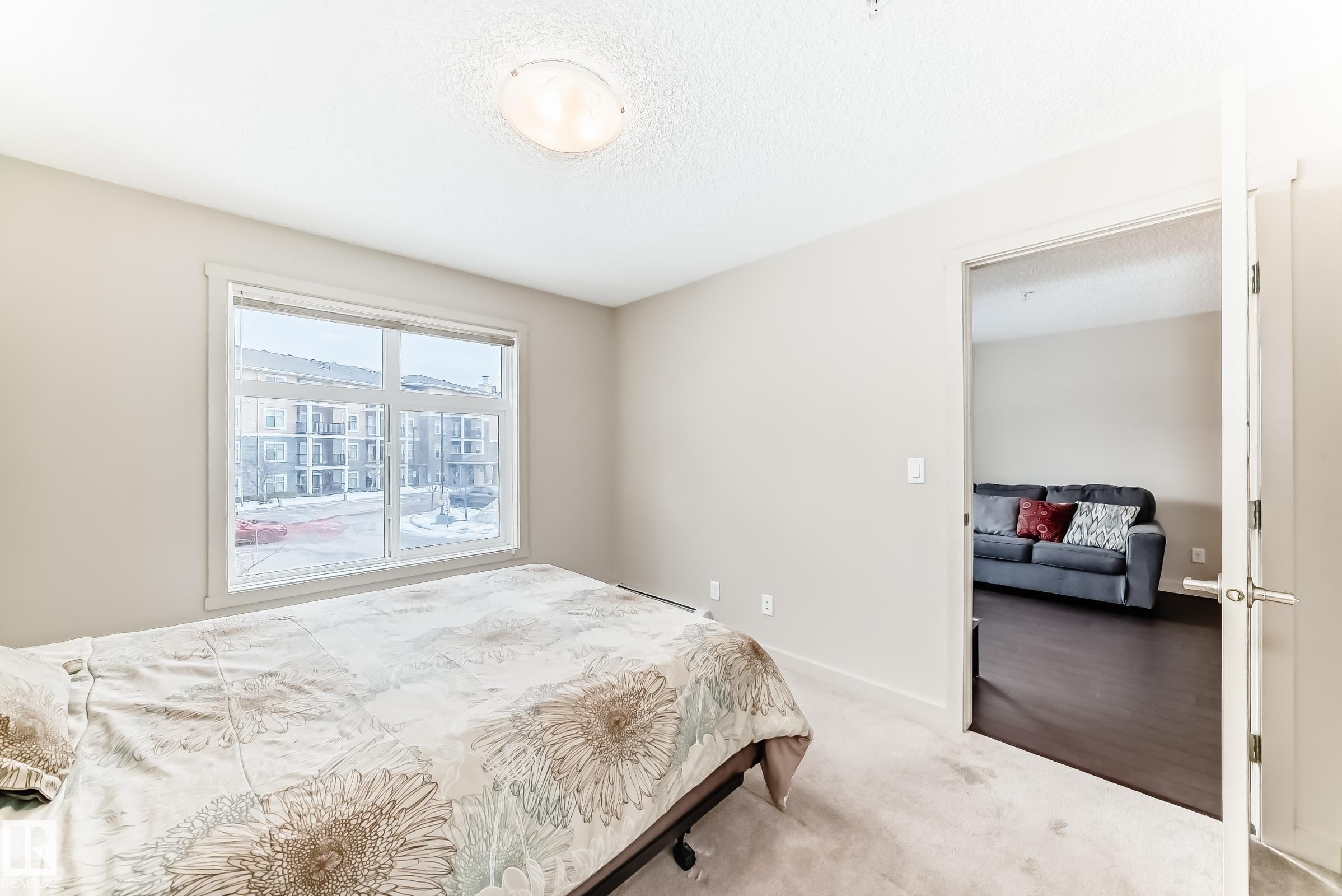 Bedroom featuring carpet floors and a textured ceiling - 229 6076 Schonsee Way, Edmonton, AB - Indoor Photo Showing Bedroom