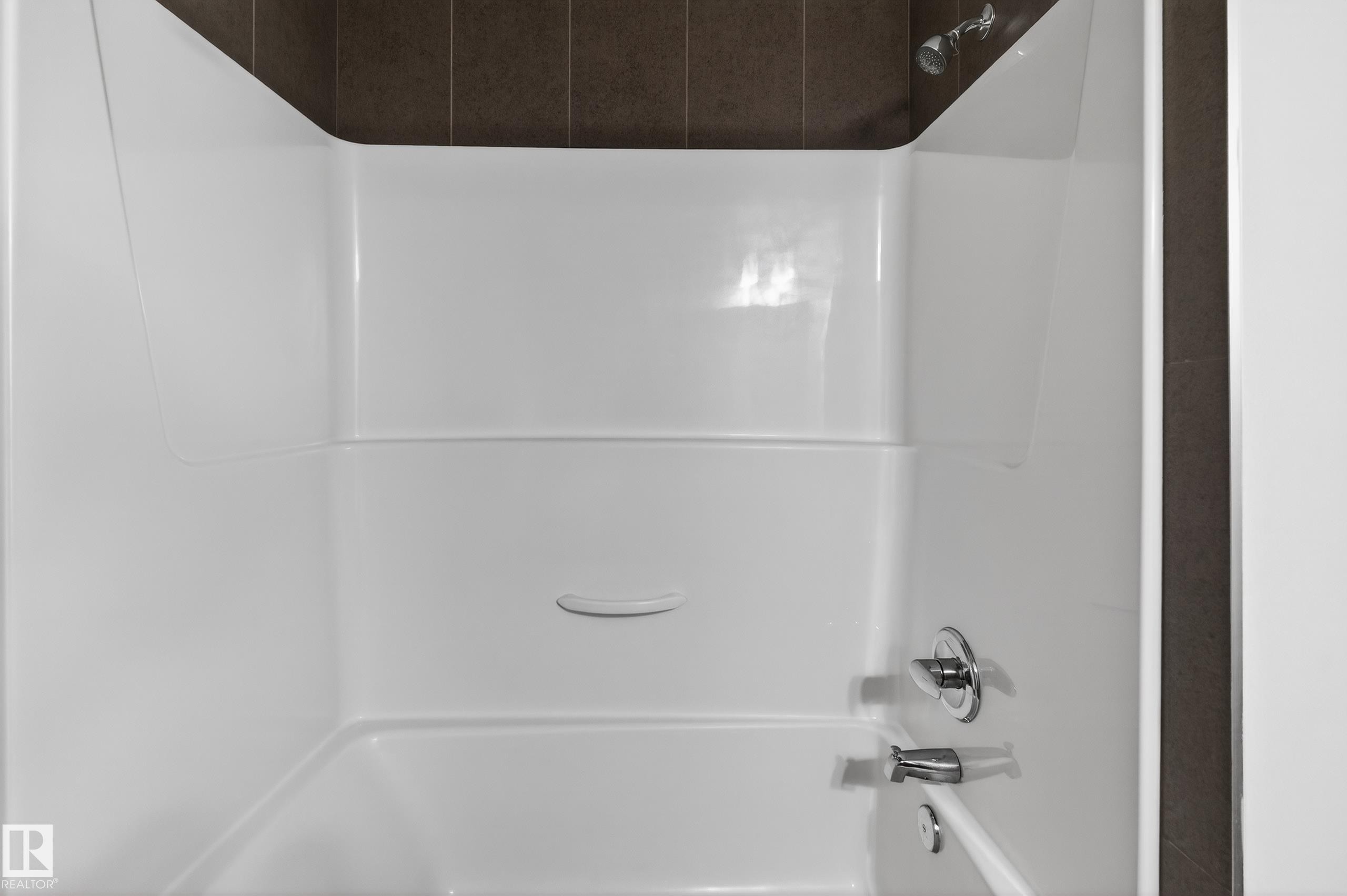 The bathroom features a white bathtub and shower combination with chrome fixtures - 1649 Cunningham Way, Edmonton, AB - Indoor Photo Showing Bathroom