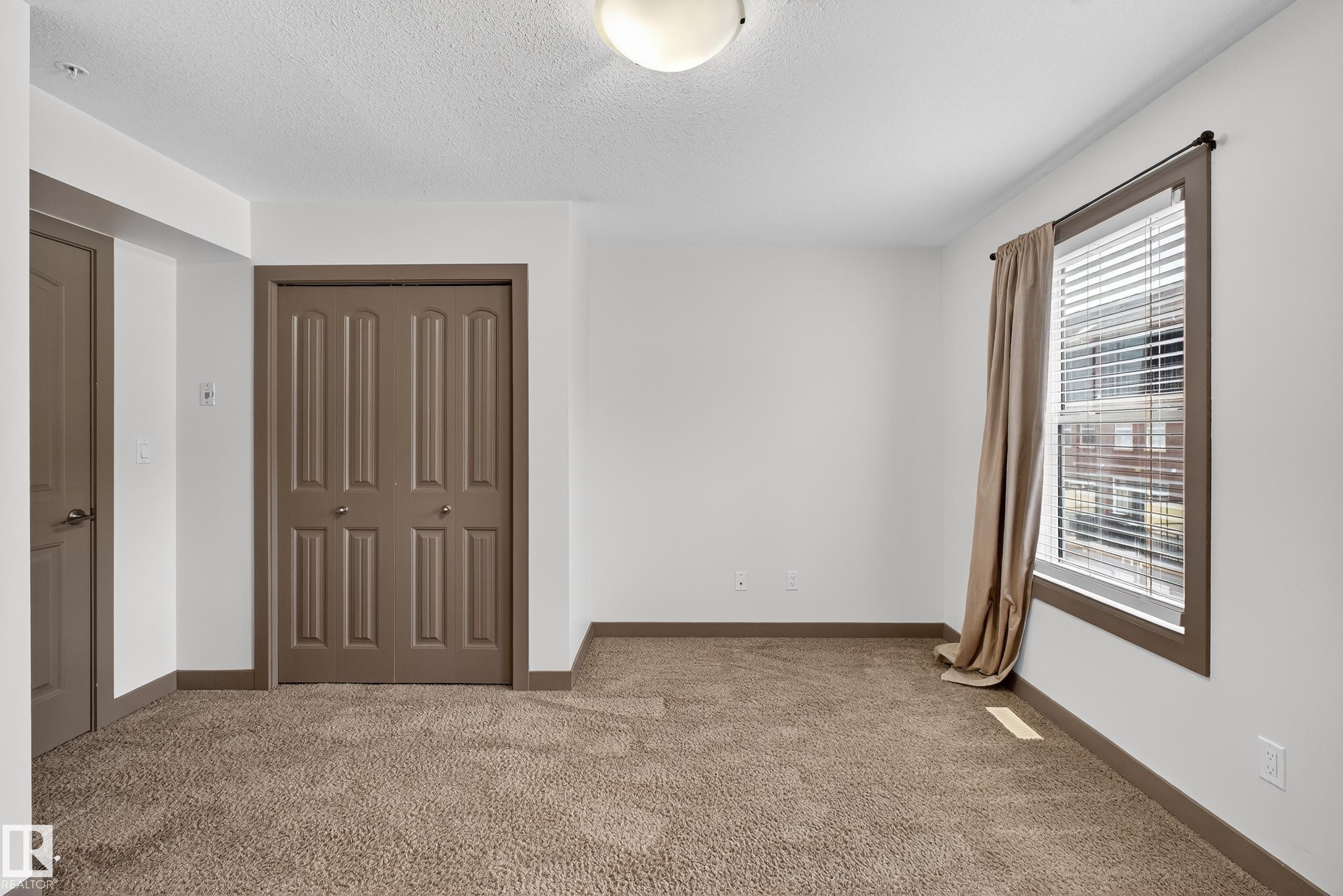 This room features plush carpeting and white walls, offering a neutral palette - 1649 Cunningham Way, Edmonton, AB - Indoor Photo Showing Other Room