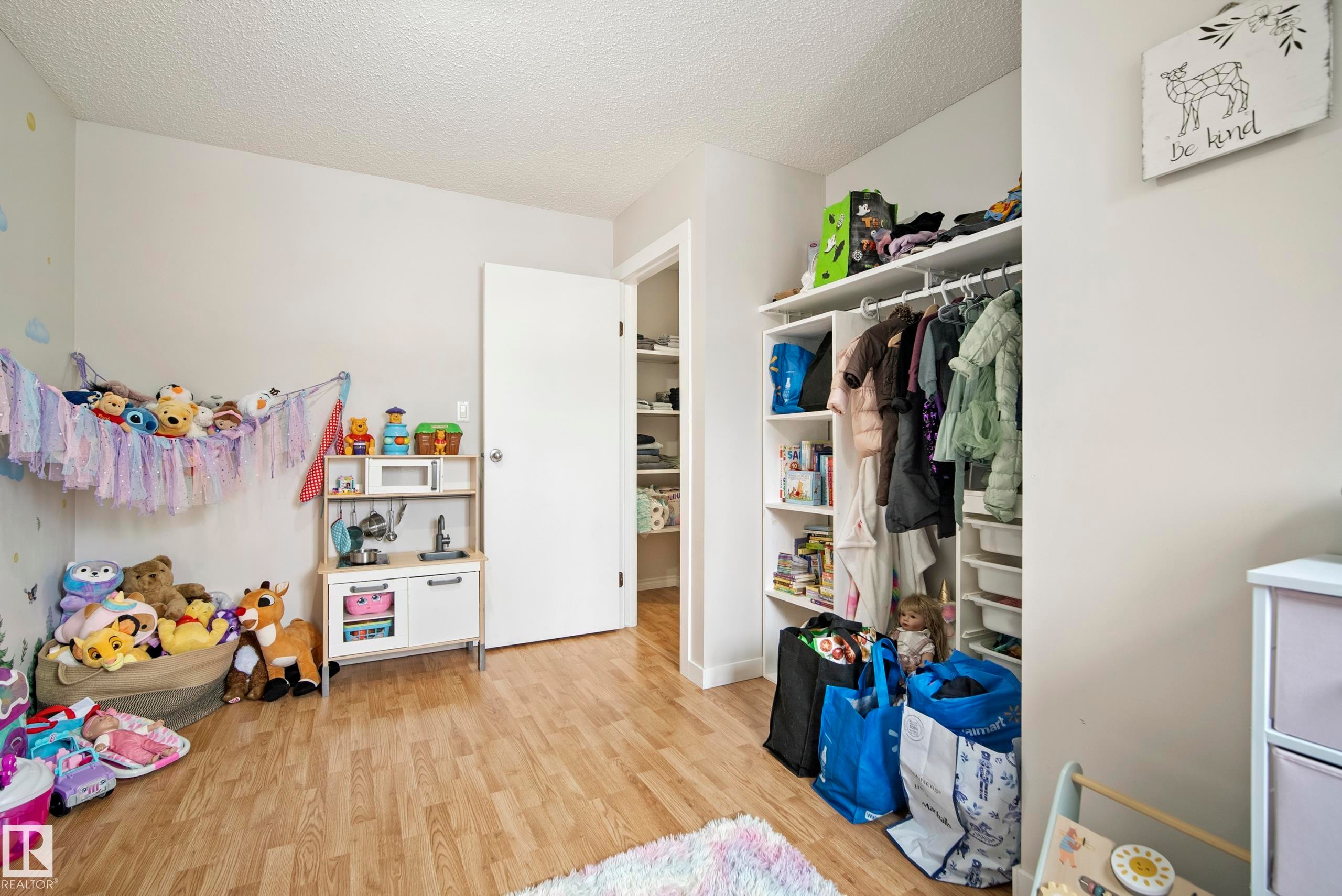 Bedroom with light wood-style floors, a textured ceiling, and a closet - 9221 84 Street, Fort Saskatchewan, AB - Indoor