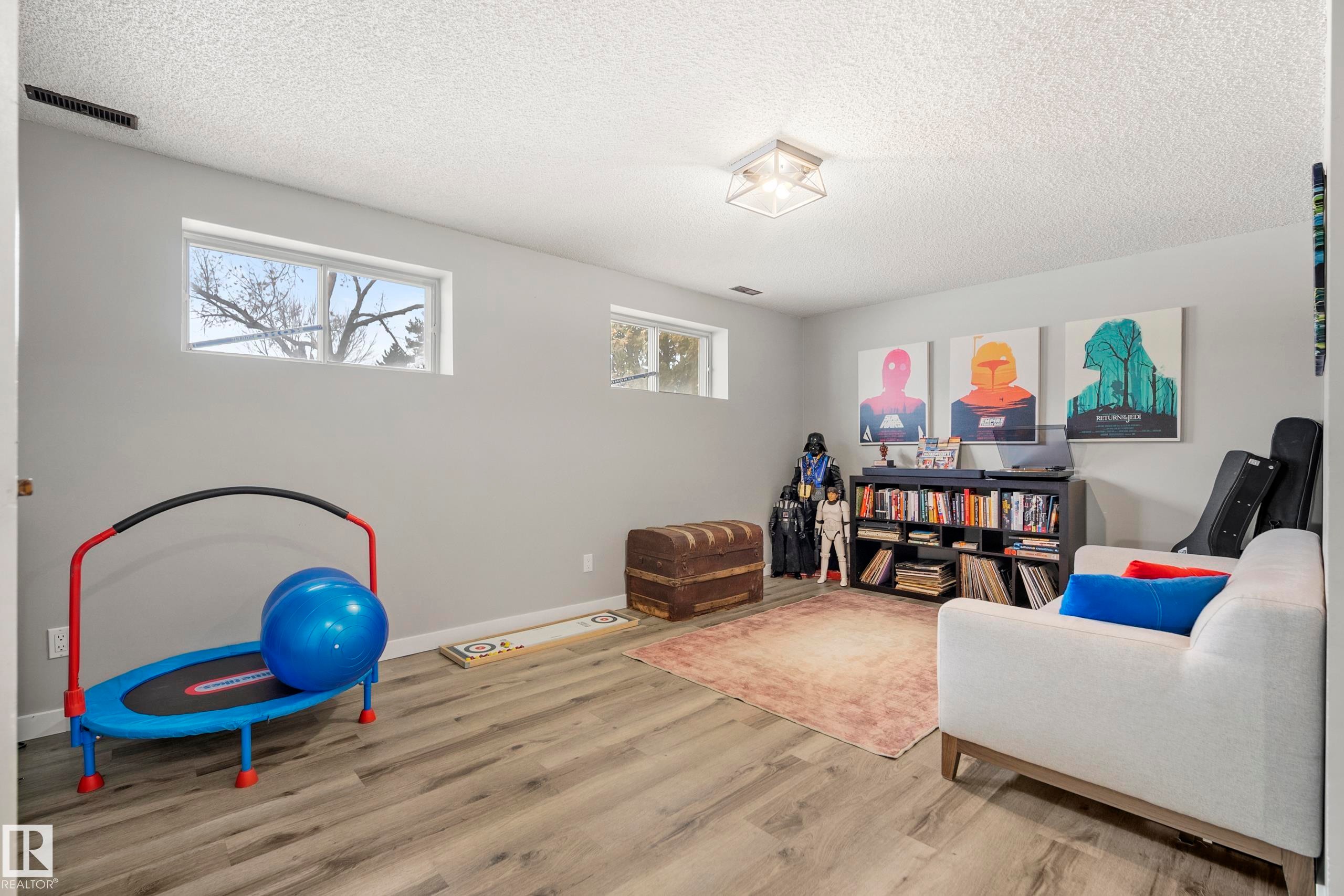 Living area featuring wood finished floors and a textured ceiling - 9221 84 Street, Fort Saskatchewan, AB - Indoor