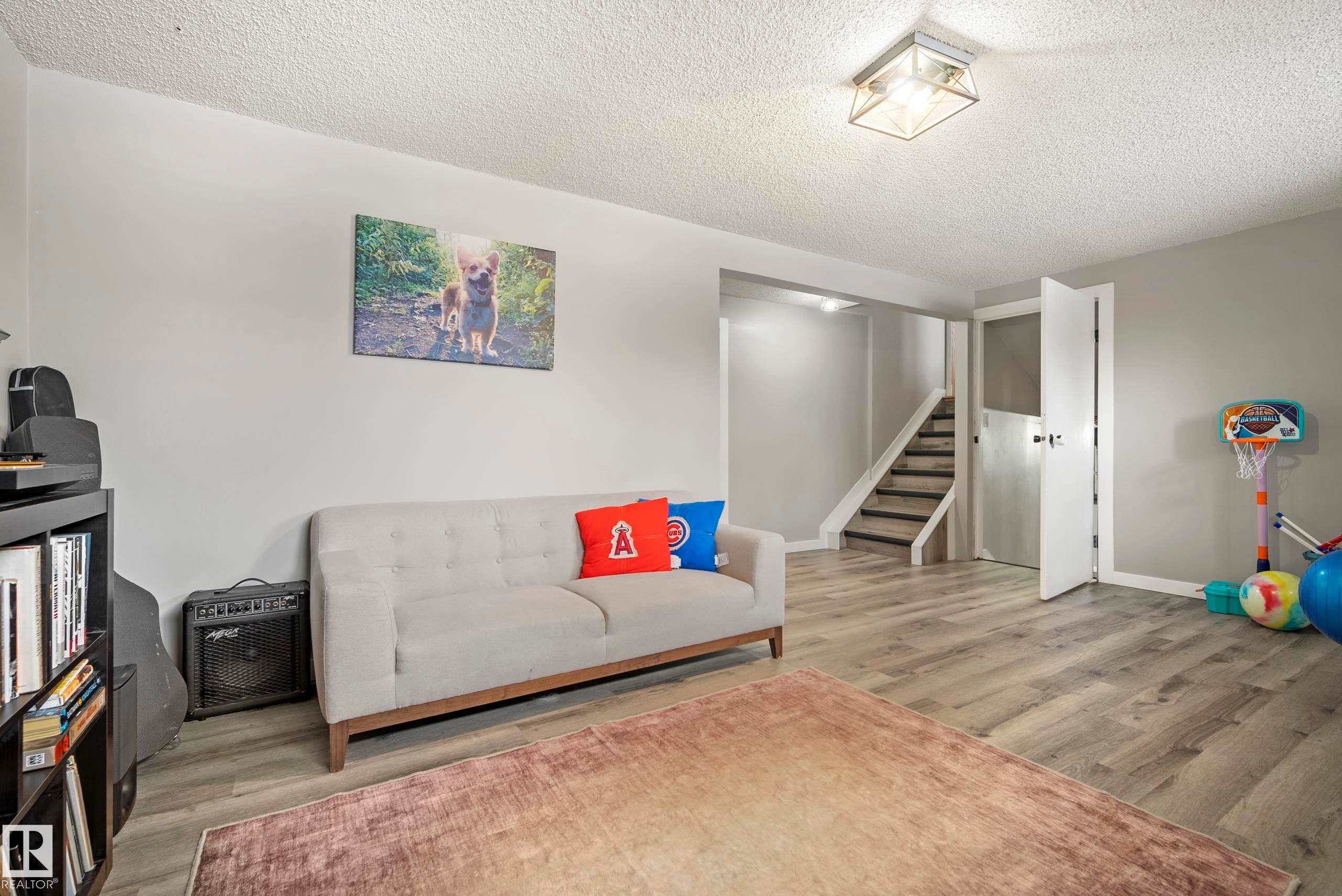 Living area featuring light wood-type flooring and a textured ceiling - 9221 84 Street, Fort Saskatchewan, AB - Indoor