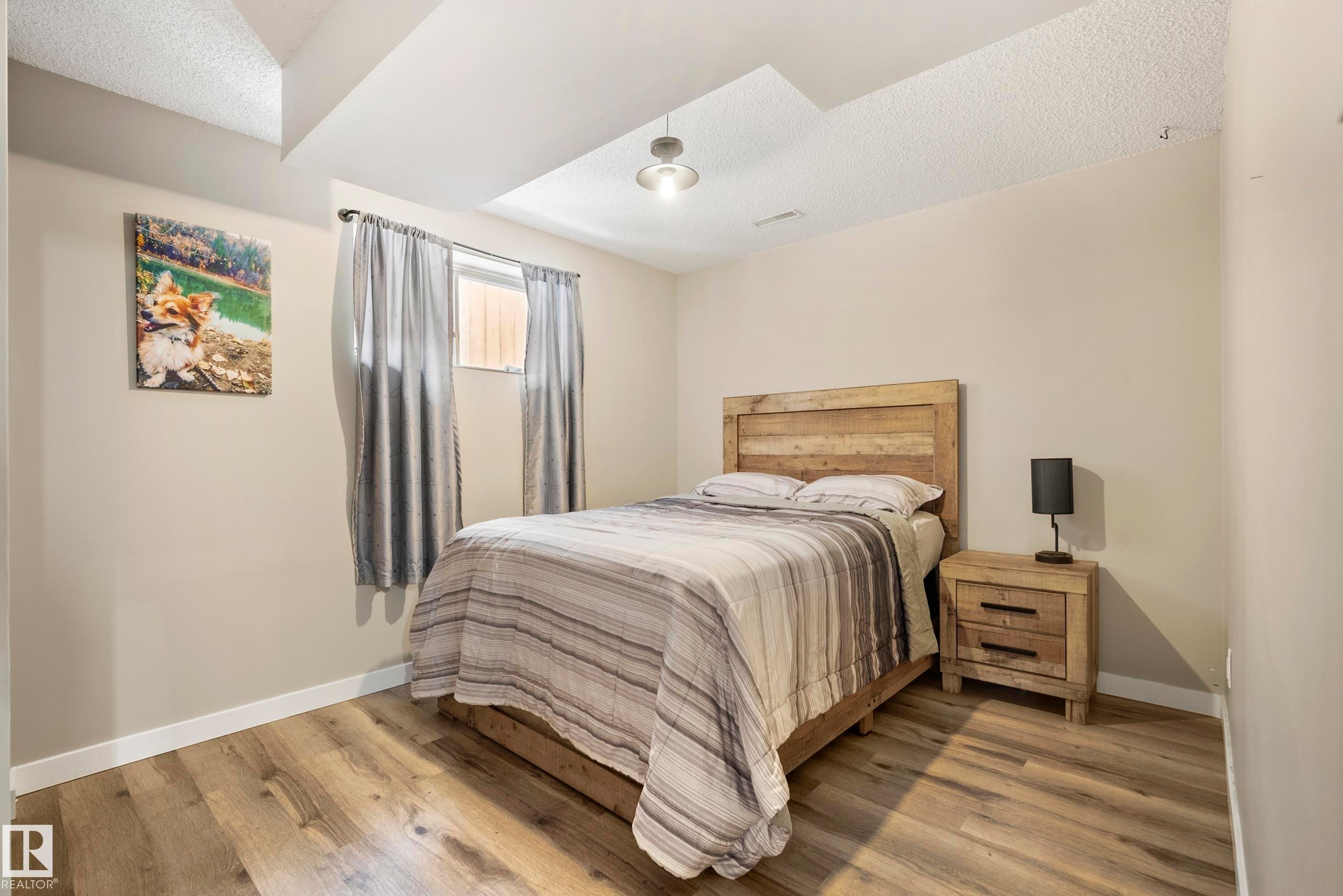 Bedroom with light wood finished floors and a textured ceiling - 9221 84 Street, Fort Saskatchewan, AB - Indoor Photo Showing Bedroom