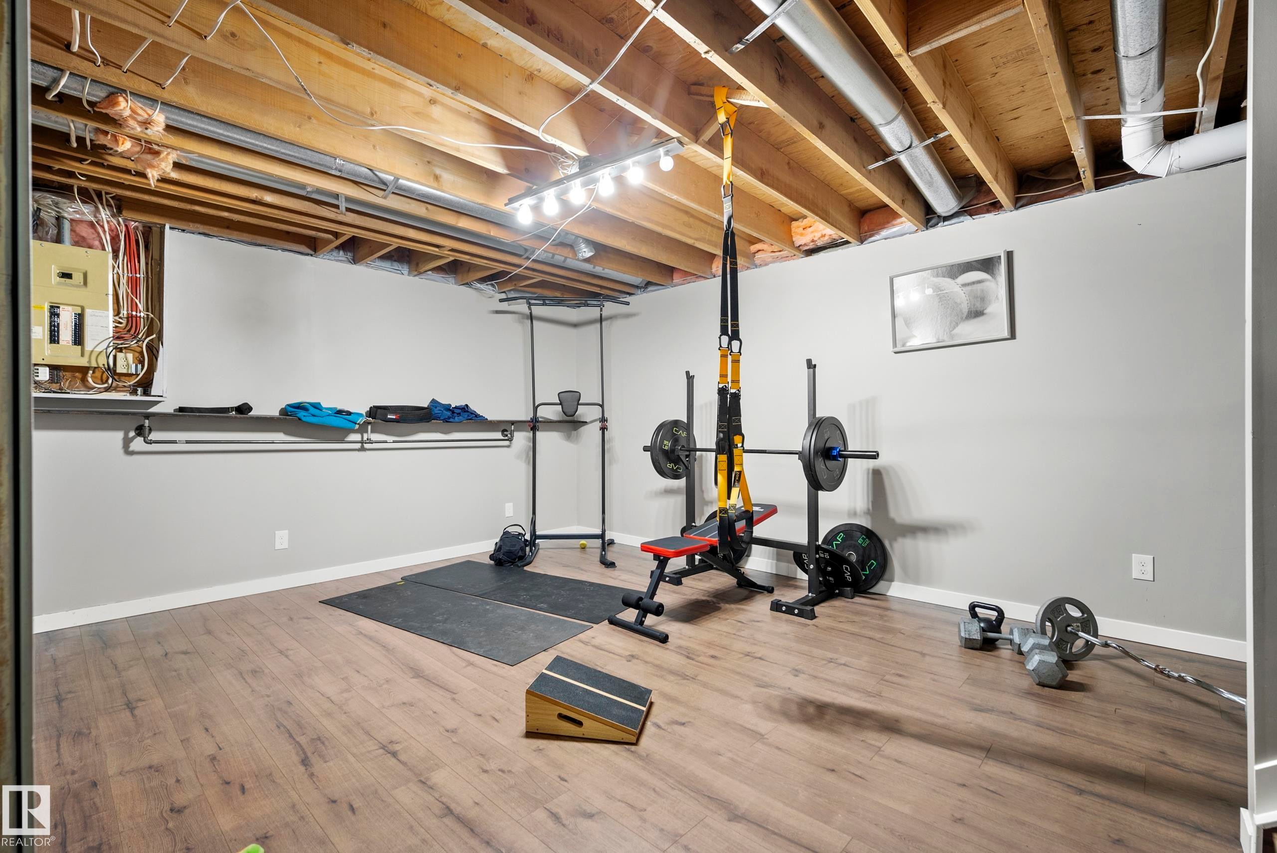 Exercise area with light wood-type flooring and electric panel - 9221 84 Street, Fort Saskatchewan, AB - Indoor Photo Showing Gym Room