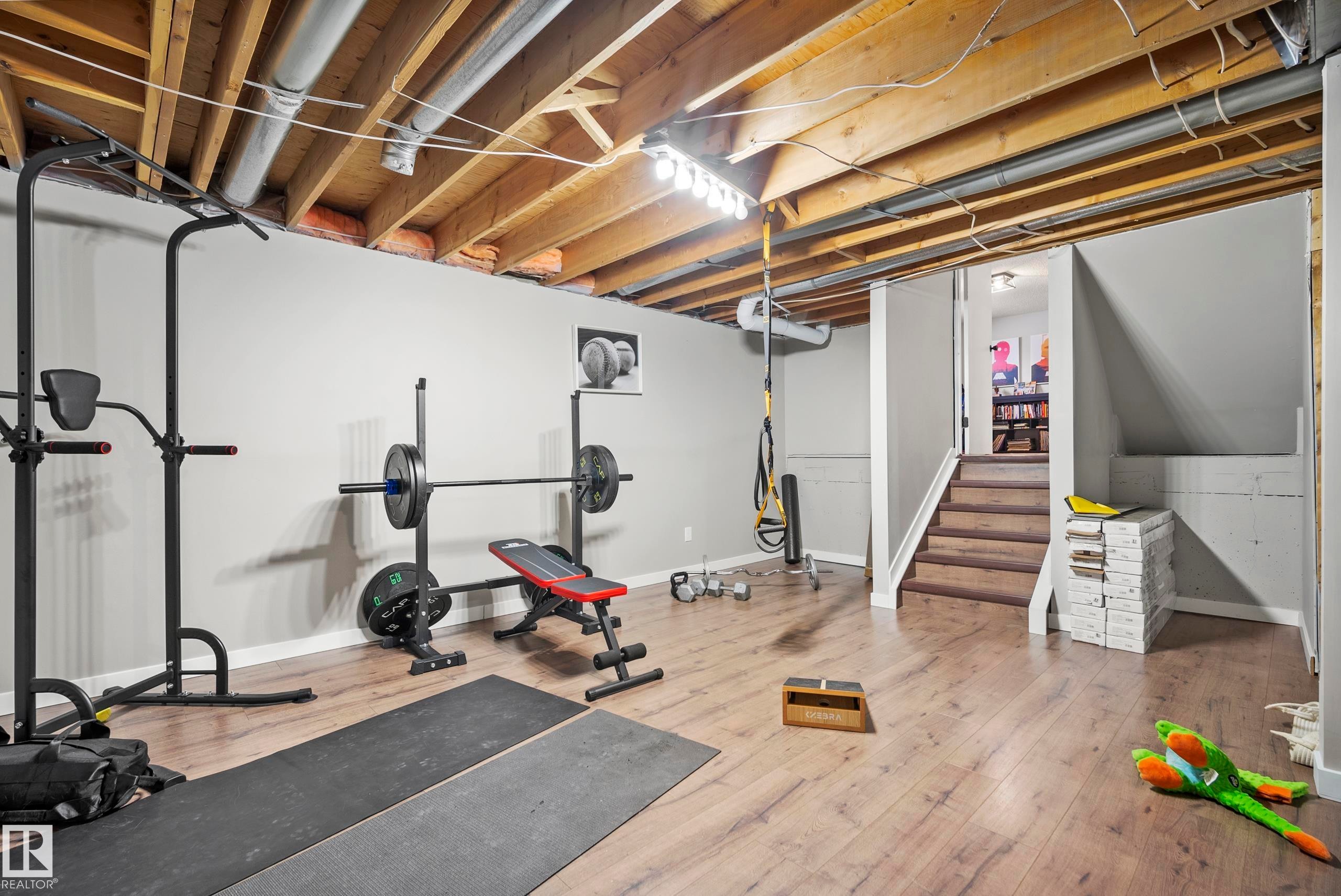 Workout area with light wood-type flooring and baseboards - 9221 84 Street, Fort Saskatchewan, AB - Indoor Photo Showing Gym Room