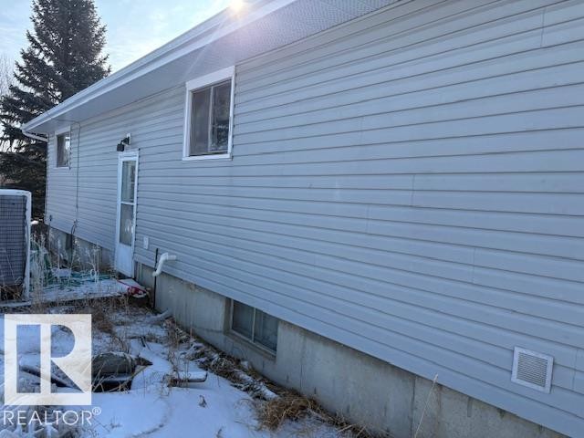 View of side of home featuring a central air condition unit and crawl space - Rural Strathcona County, AB - Outdoor With Exterior
