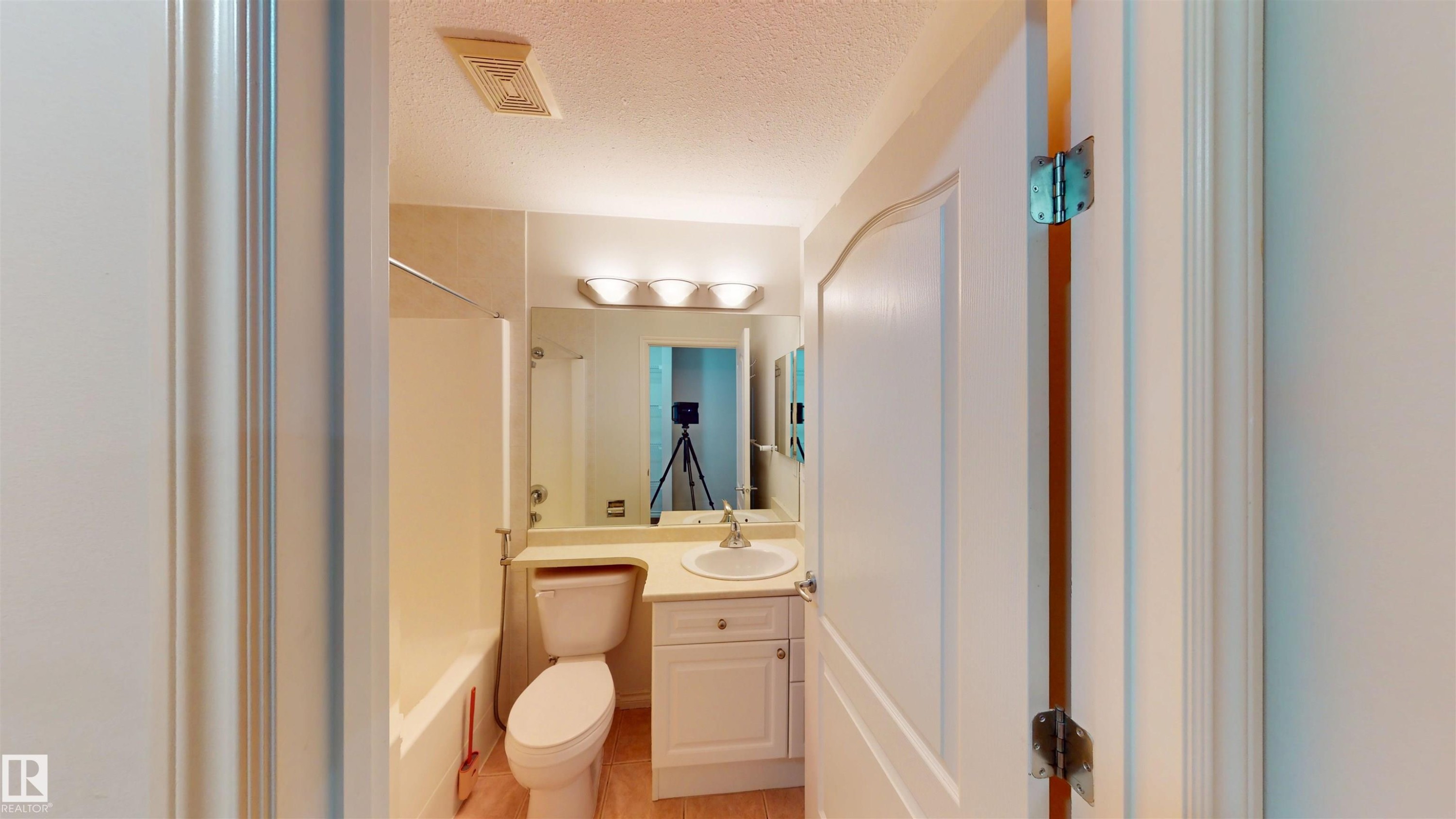 Full bath featuring vanity, a textured ceiling, and shower / washtub combination - 115 9938 104 St, Edmonton, AB - Indoor Photo Showing Bathroom