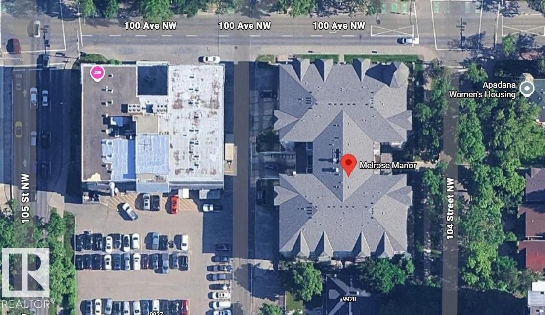 Aerial view of the property, Melrose Manor, featuring a large multi-unit structure with a grey roof, situated near a street - 115 9938 104 St, Edmonton, AB - Other