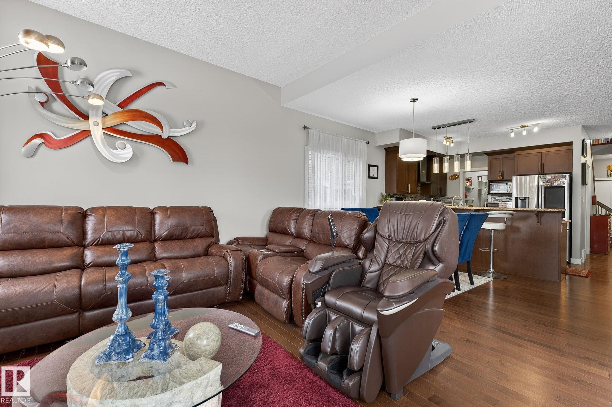 Living room with dark wood-style floors, a textured ceiling, and track lighting - 21867 80 Avenue, Edmonton, AB - Indoor Photo Showing Living Room