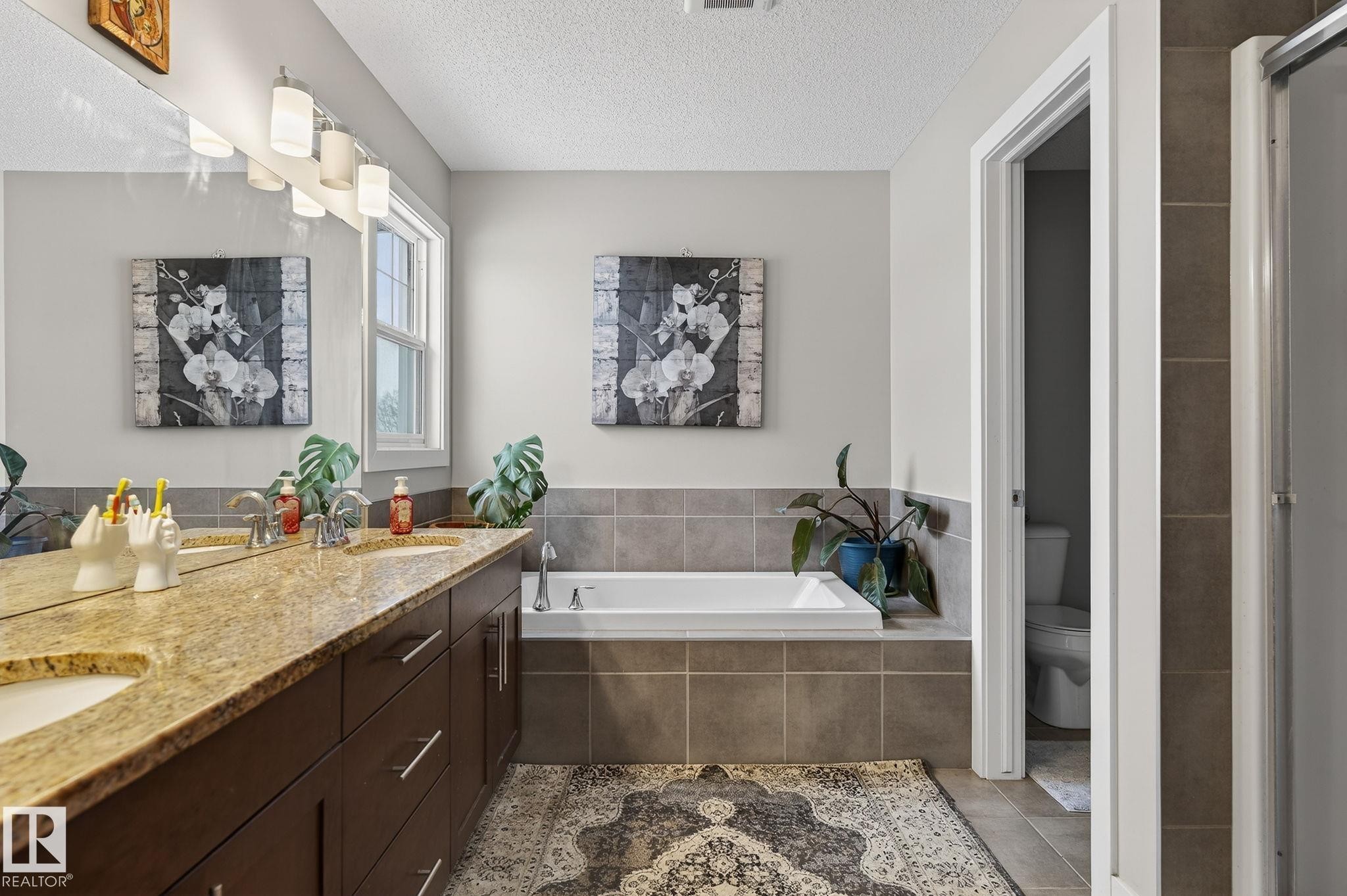 Bathroom featuring double vanity, a garden tub, and a textured ceiling - 21867 80 Avenue, Edmonton, AB - Indoor Photo Showing Bathroom