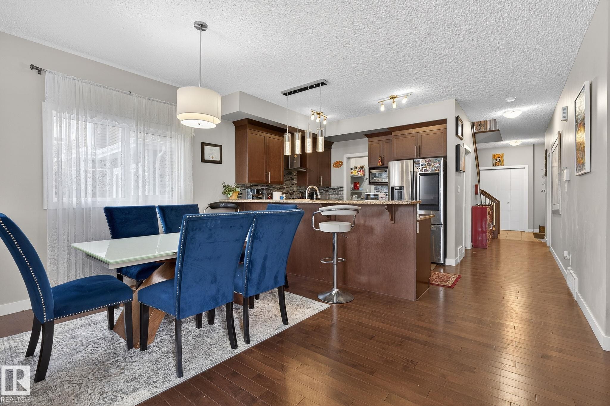 Dining room featuring dark wood-style flooring and a textured ceiling - 21867 80 Avenue, Edmonton, AB - Indoor