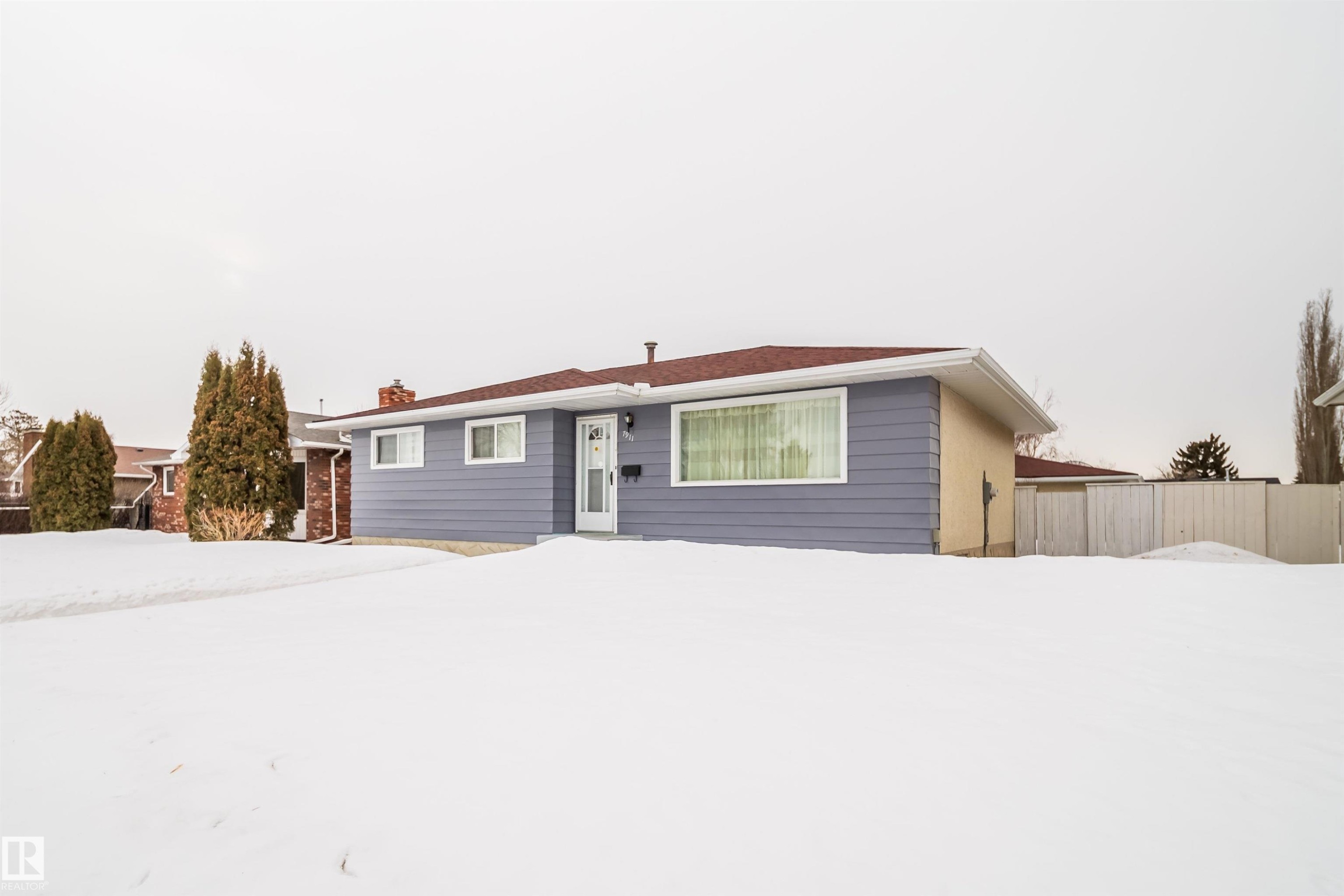 This property features a single-story residence with light blue siding and a red roof, complemented by white trim and a front door - 7911 145 Avenue Nw, Edmonton, AB - Outdoor