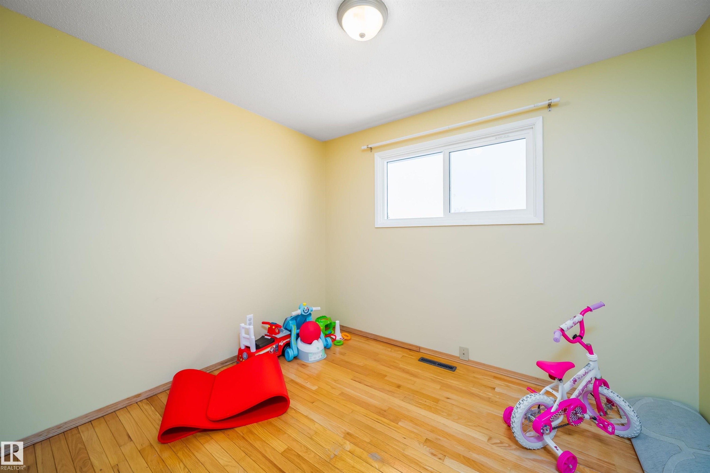 This room features hardwood floors and a window providing natural light - 7911 145 Avenue Nw, Edmonton, AB - Indoor