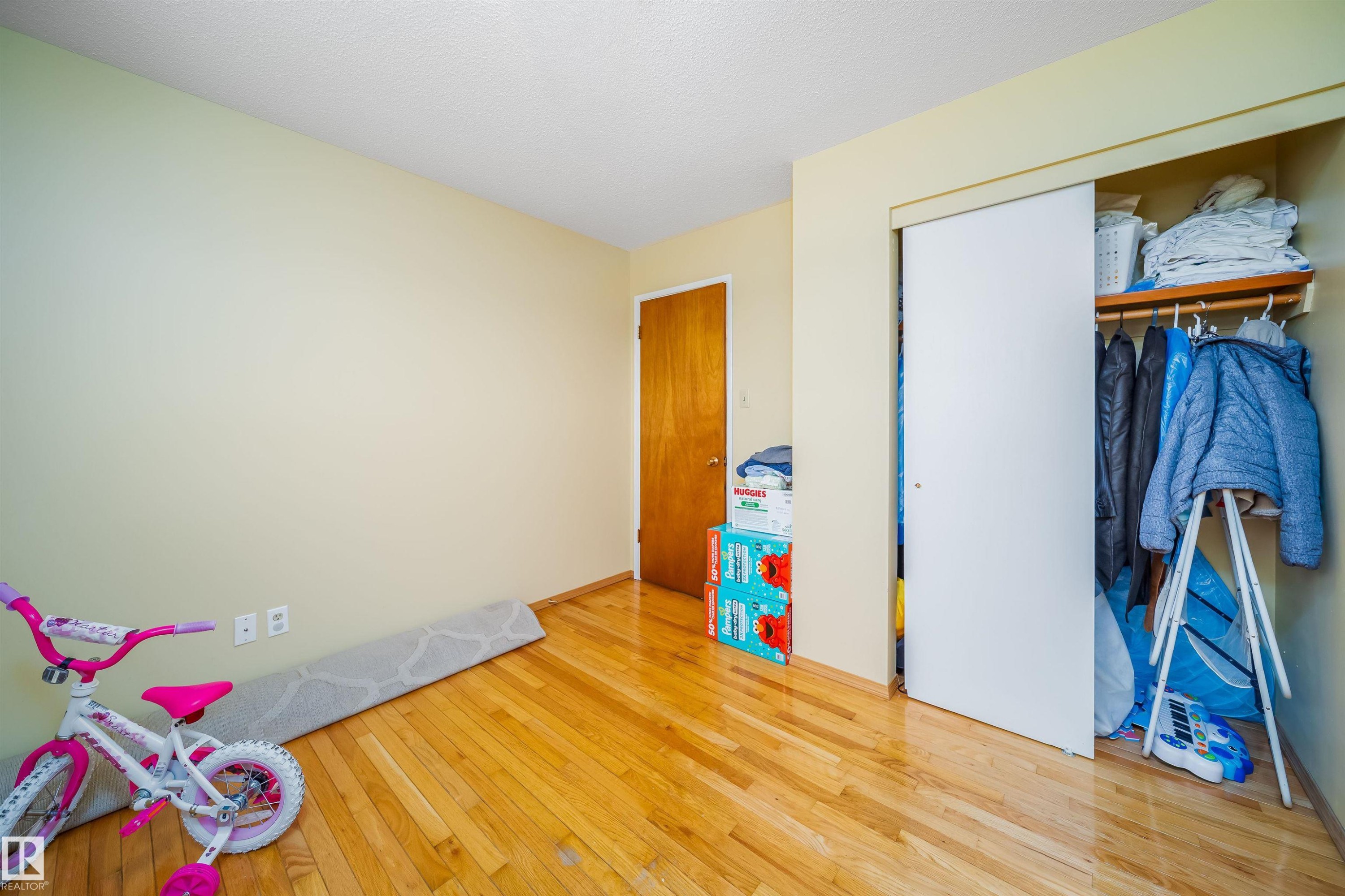 This room features hardwood floors and a closet with a sliding door - 7911 145 Avenue Nw, Edmonton, AB - Indoor