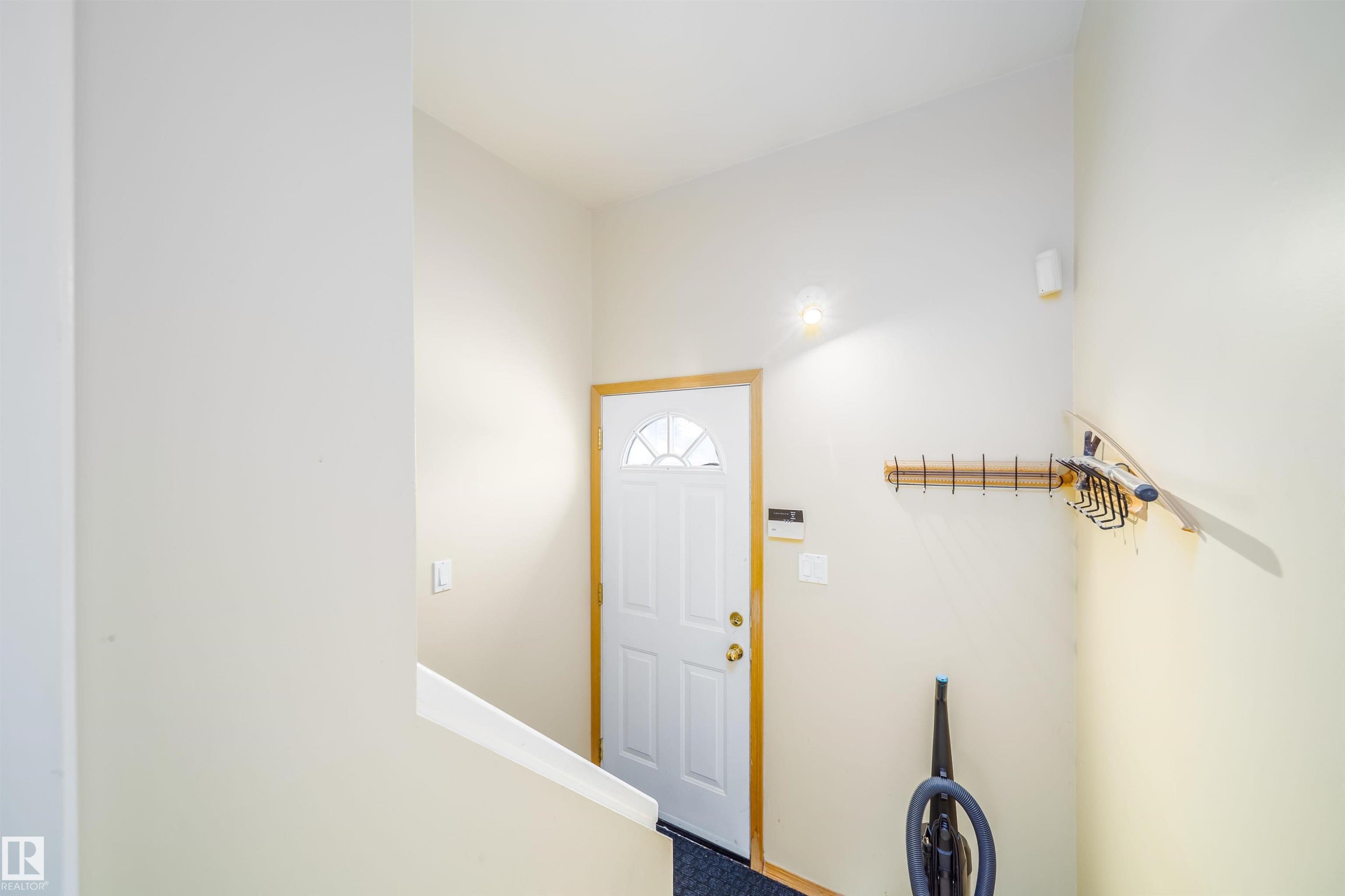 Entryway featuring a white paneled door with an arched window, light-colored walls, and a light fixture - 7911 145 Avenue Nw, Edmonton, AB - Indoor Photo Showing Other Room