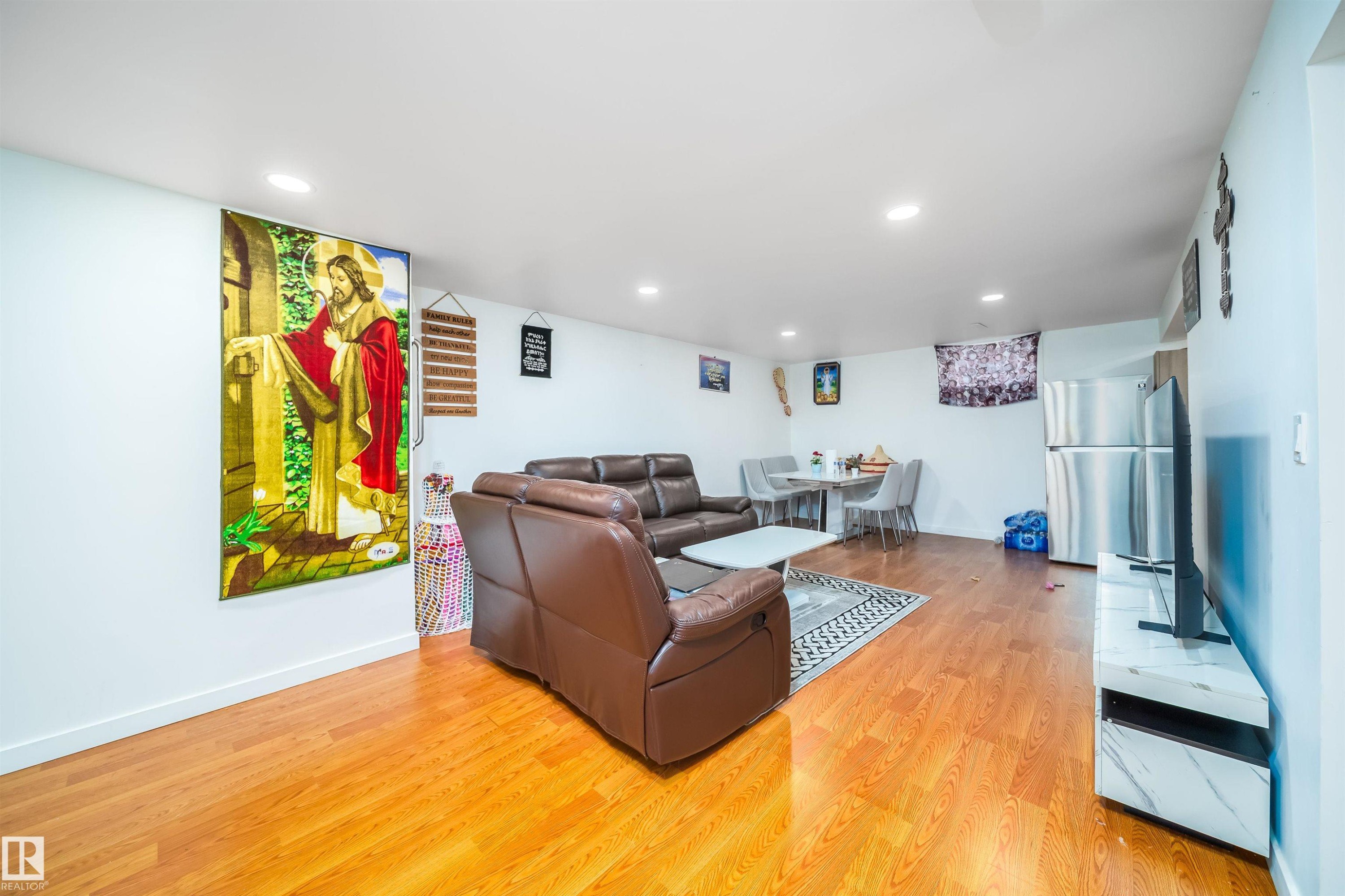 This versatile space features light wood flooring and recessed lighting, offering a bright and inviting atmosphere - 7911 145 Avenue Nw, Edmonton, AB - Indoor