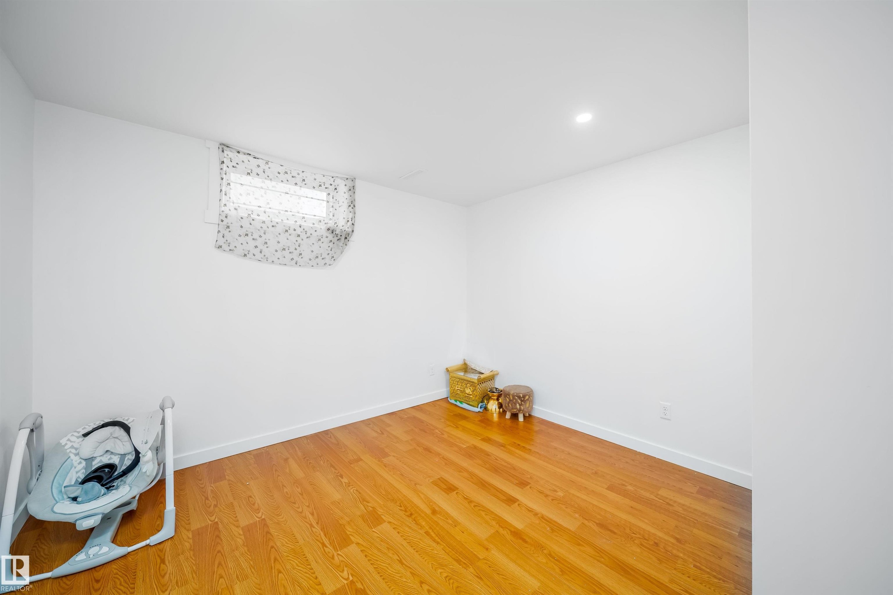 This room features hardwood flooring, white walls, and a recessed ceiling light - 7911 145 Avenue Nw, Edmonton, AB - Indoor Photo Showing Other Room