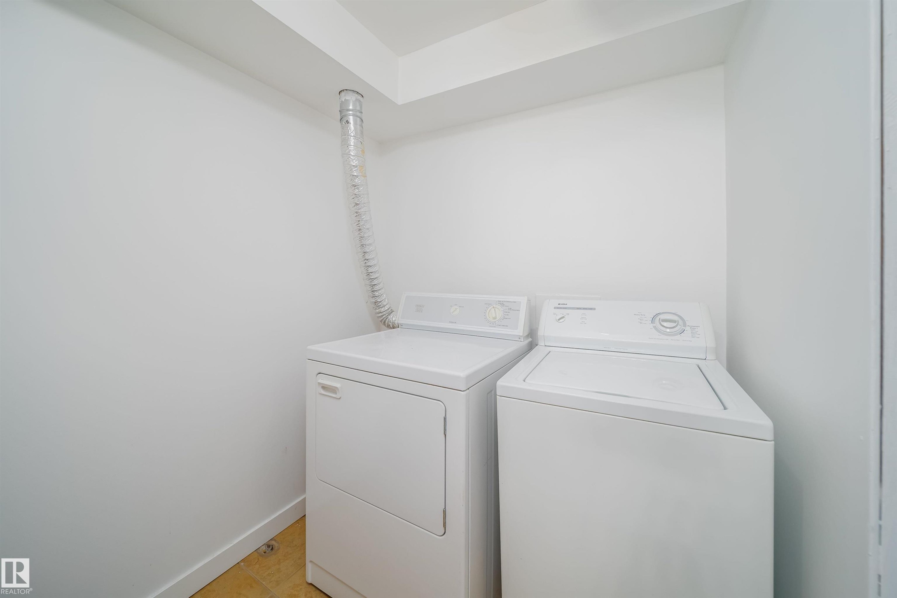 Dedicated laundry area with a white washing machine and dryer, featuring a dryer vent - 7911 145 Avenue Nw, Edmonton, AB - Indoor Photo Showing Laundry Room