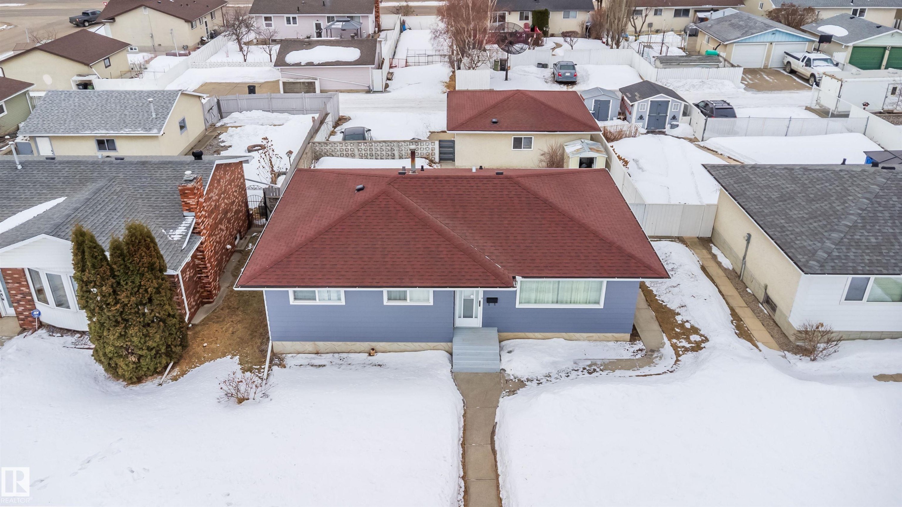 This property features a red roof and light blue exterior, with a front walkway leading to the entrance - 7911 145 Avenue Nw, Edmonton, AB - Outdoor