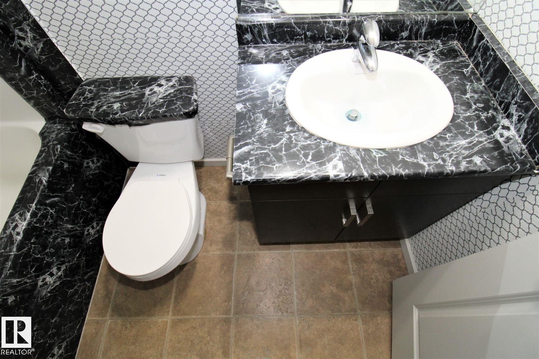 Bathroom featuring vanity and tile walls - 430 5515 7 Avenue, Edmonton, AB - Indoor Photo Showing Bathroom