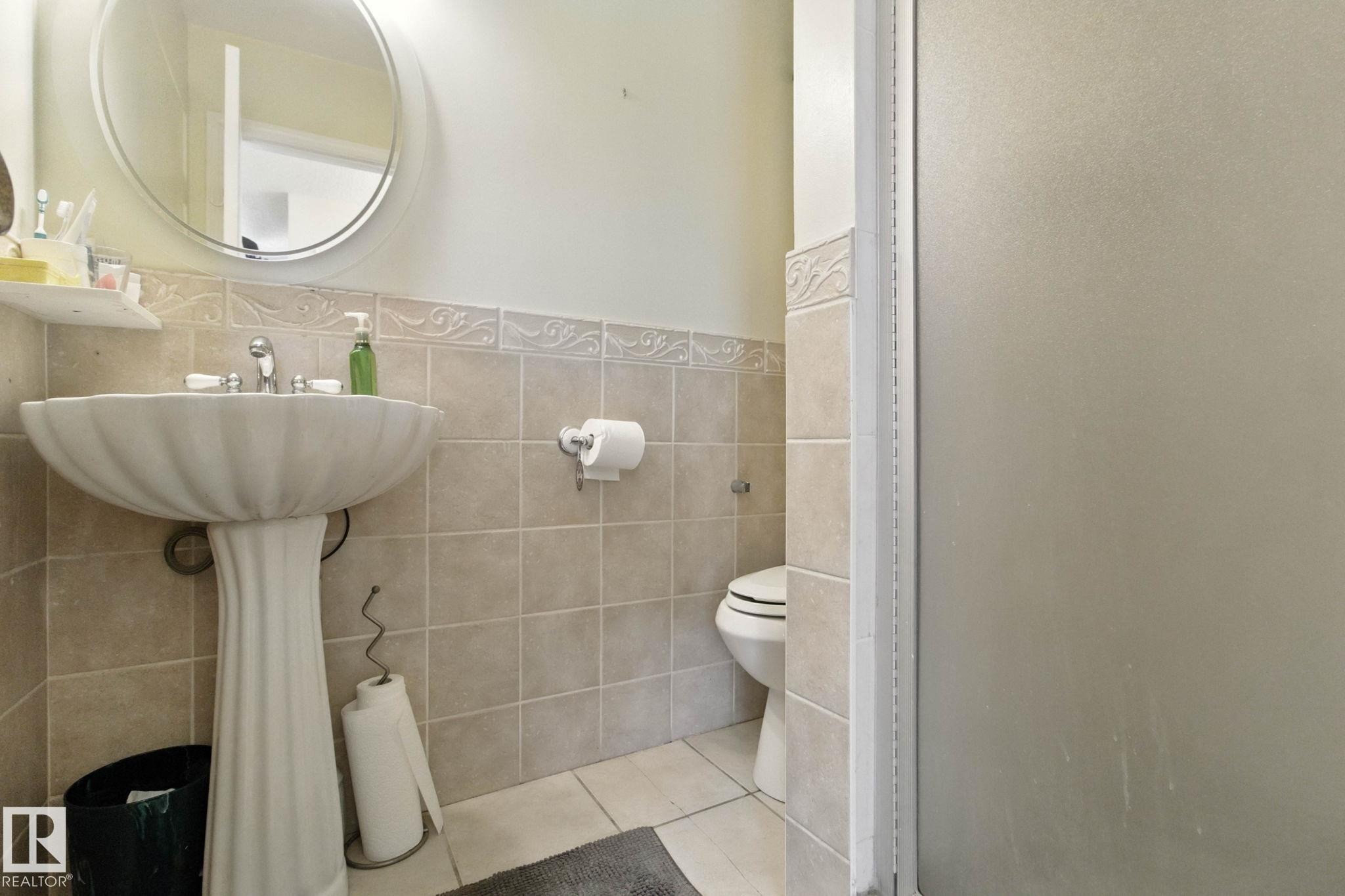 Full bathroom featuring tile walls, a stall shower, tile patterned floors, and a wainscoted wall - 39 Grand Meadow Crescent, Edmonton, AB - Indoor Photo Showing Bathroom