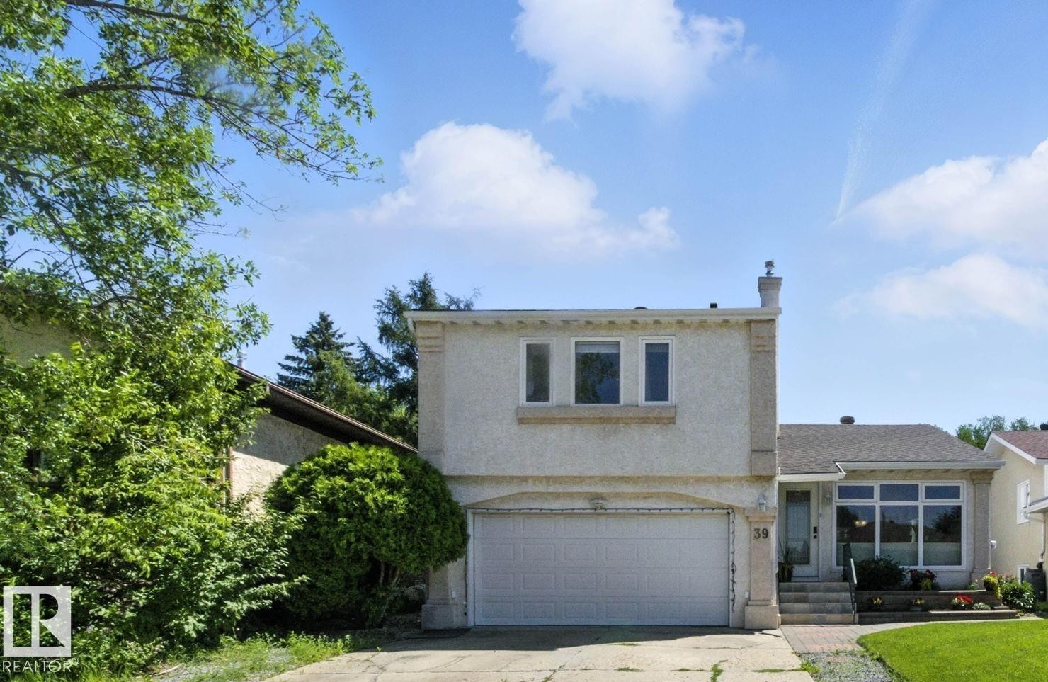 View of front of home featuring an attached garage, stucco siding, and driveway - 39 Grand Meadow Crescent, Edmonton, AB - Outdoor
