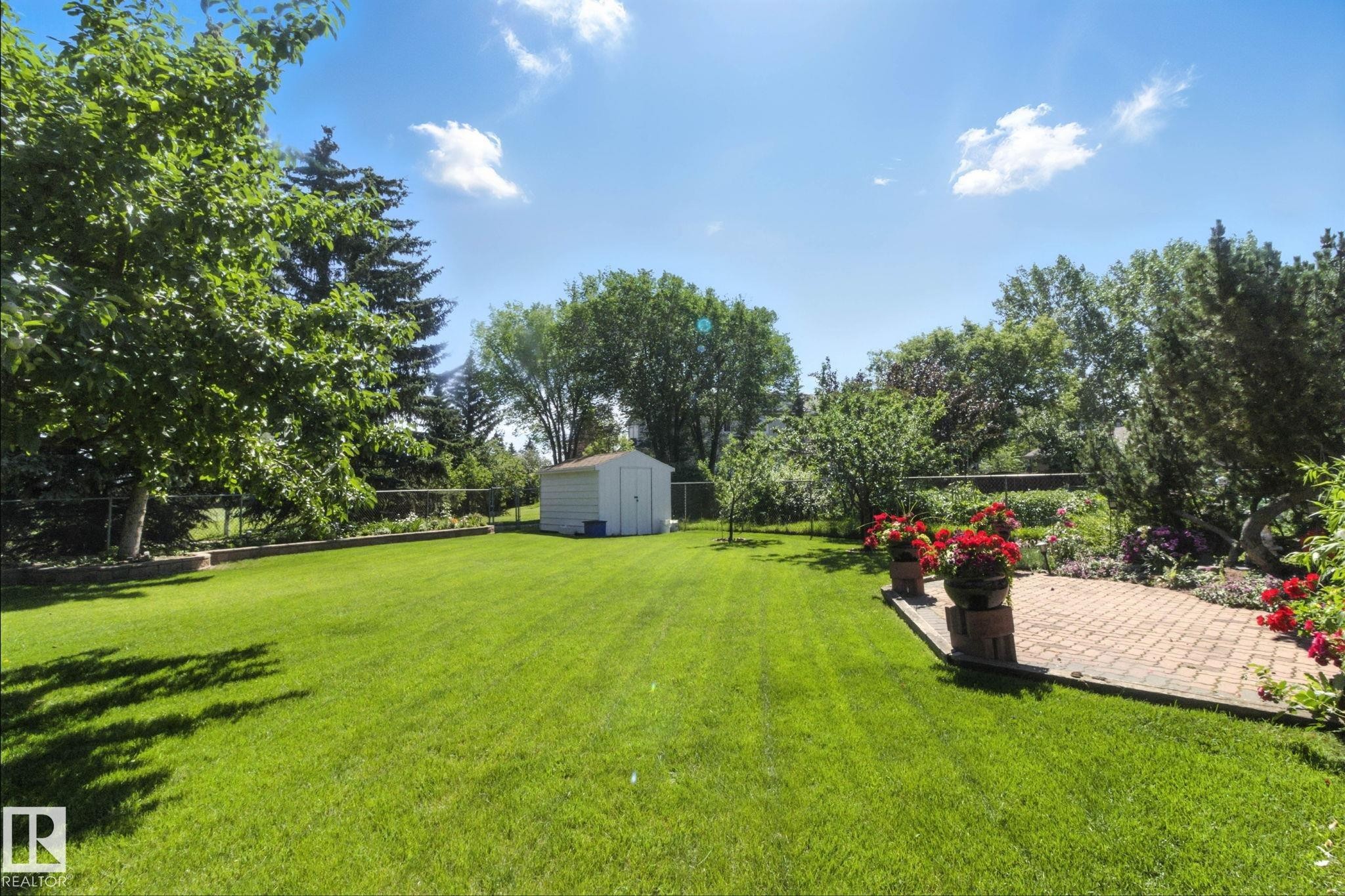 Fenced backyard with a storage unit and a patio area - 39 Grand Meadow Crescent, Edmonton, AB - Outdoor