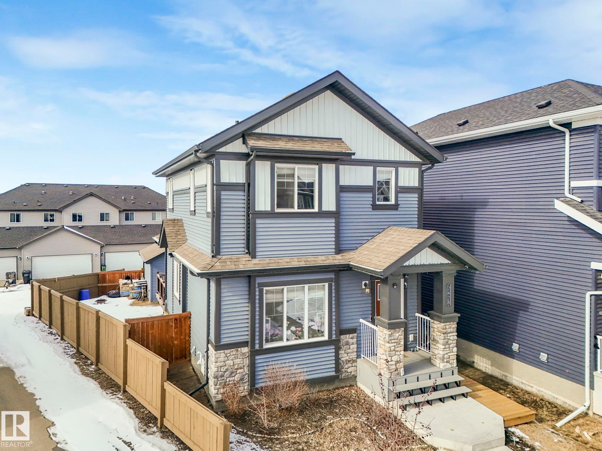 View of front of property with roof with shingles, stone siding, board and batten siding, and a residential view - 2428 Wonnacott Crest, Edmonton, AB - Outdoor