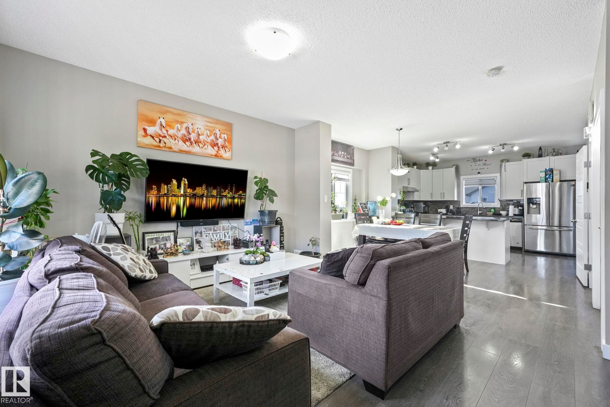 Living area featuring dark wood finished floors and a textured ceiling - 2428 Wonnacott Crest, Edmonton, AB - Indoor Photo Showing Living Room