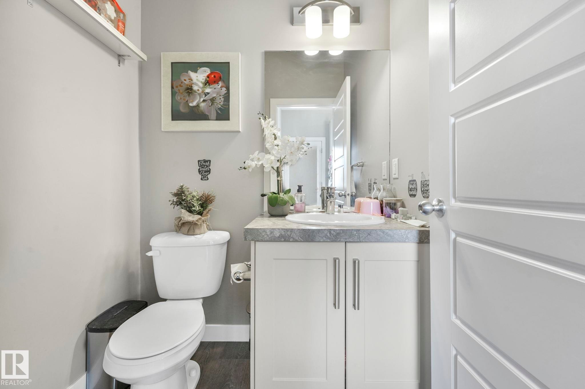 Half bathroom with vanity and dark wood-type flooring - 2428 Wonnacott Crest, Edmonton, AB - Indoor Photo Showing Bathroom