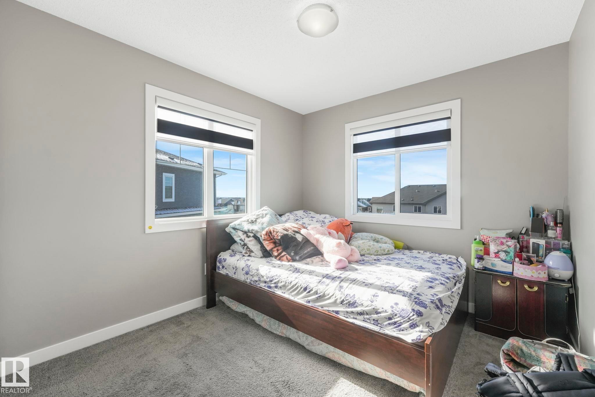 Bedroom with baseboards and light carpet - 2428 Wonnacott Crest, Edmonton, AB - Indoor Photo Showing Bedroom