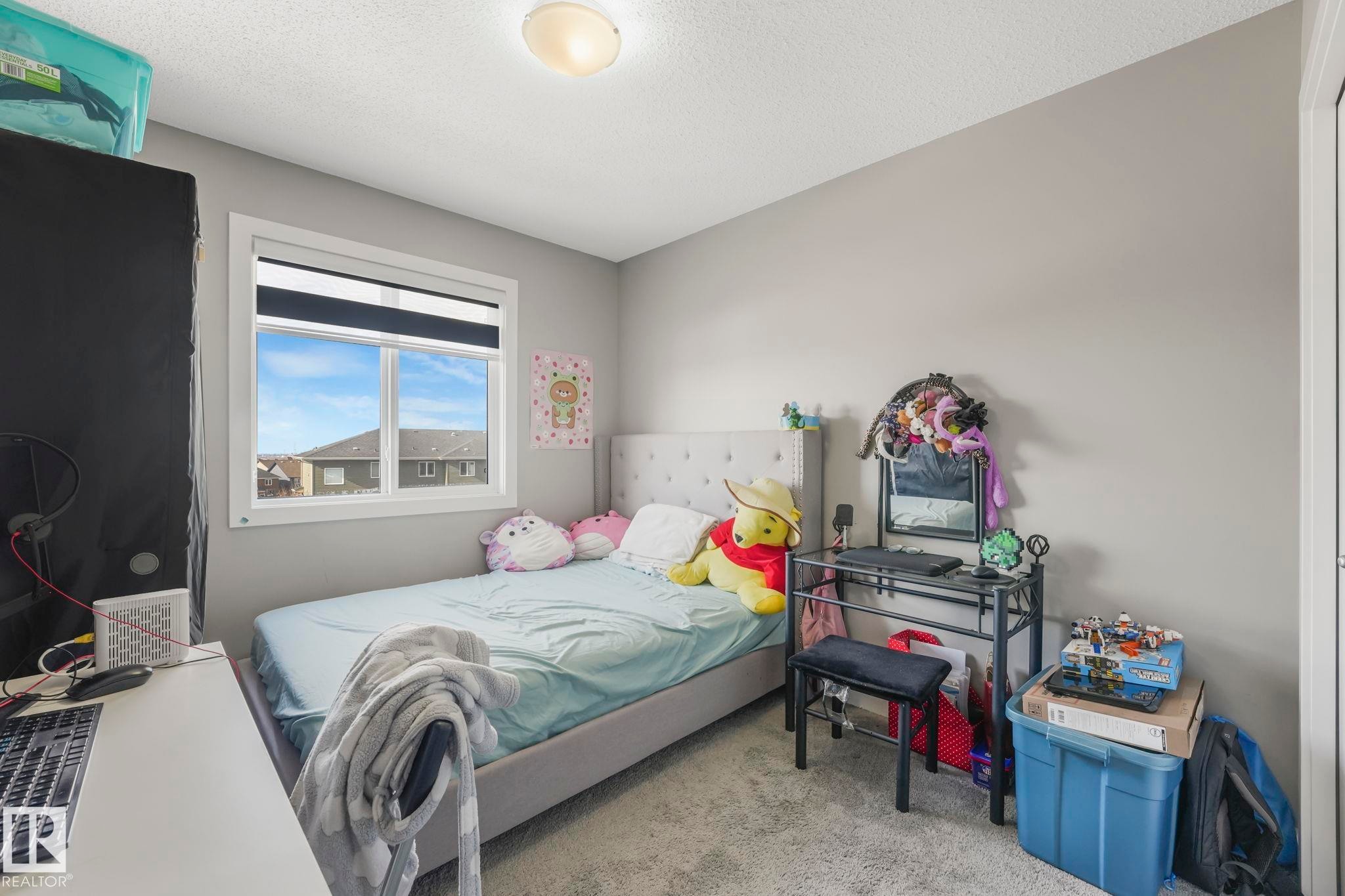 Bedroom with light carpet and a textured ceiling - 2428 Wonnacott Crest, Edmonton, AB - Indoor Photo Showing Bedroom