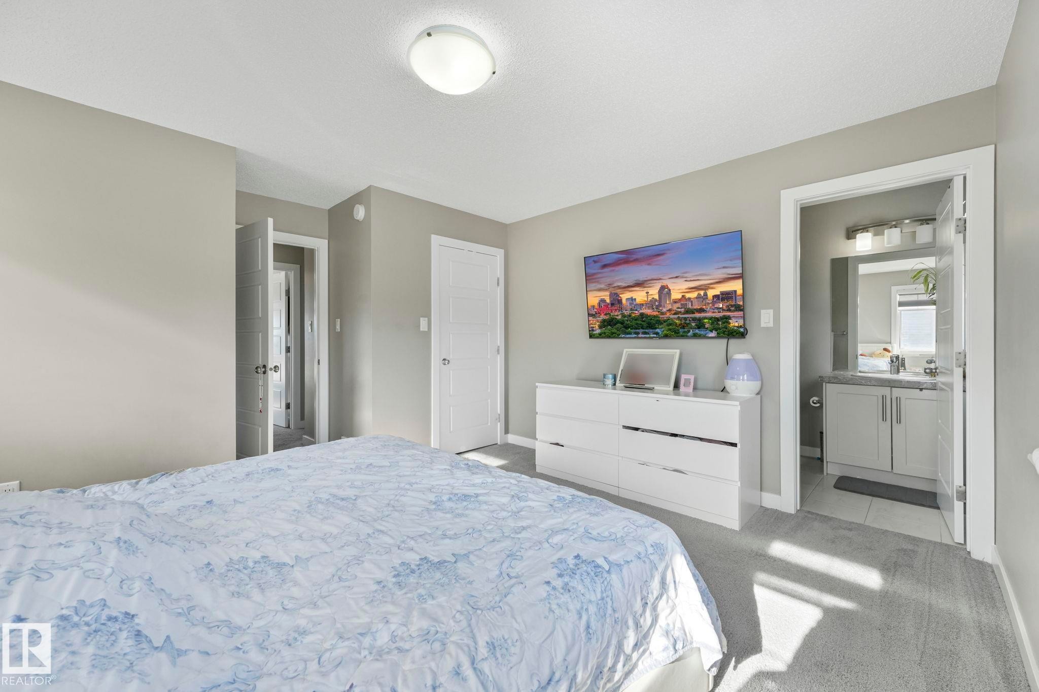 Bedroom with light colored carpet and ensuite bathroom - 2428 Wonnacott Crest, Edmonton, AB - Indoor Photo Showing Bedroom