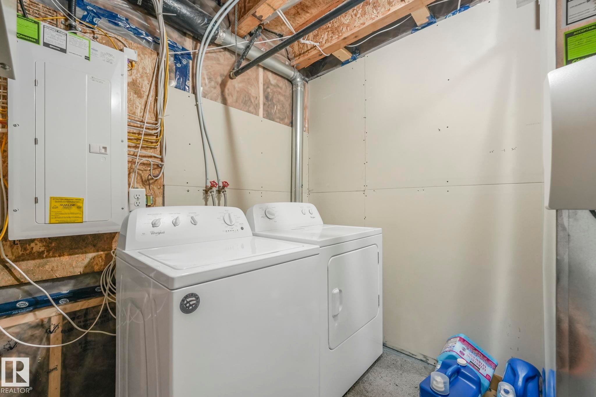 Laundry area featuring electric panel and separate washer and dryer - 2428 Wonnacott Crest, Edmonton, AB - Indoor Photo Showing Laundry Room