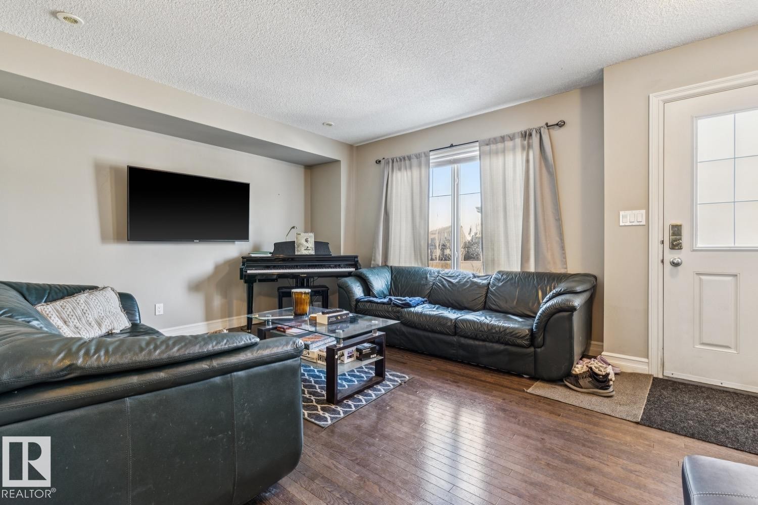 Living area featuring wood-type flooring and a textured ceiling - 5409 3 Avenue, Edmonton, AB - Indoor Photo Showing Living Room
