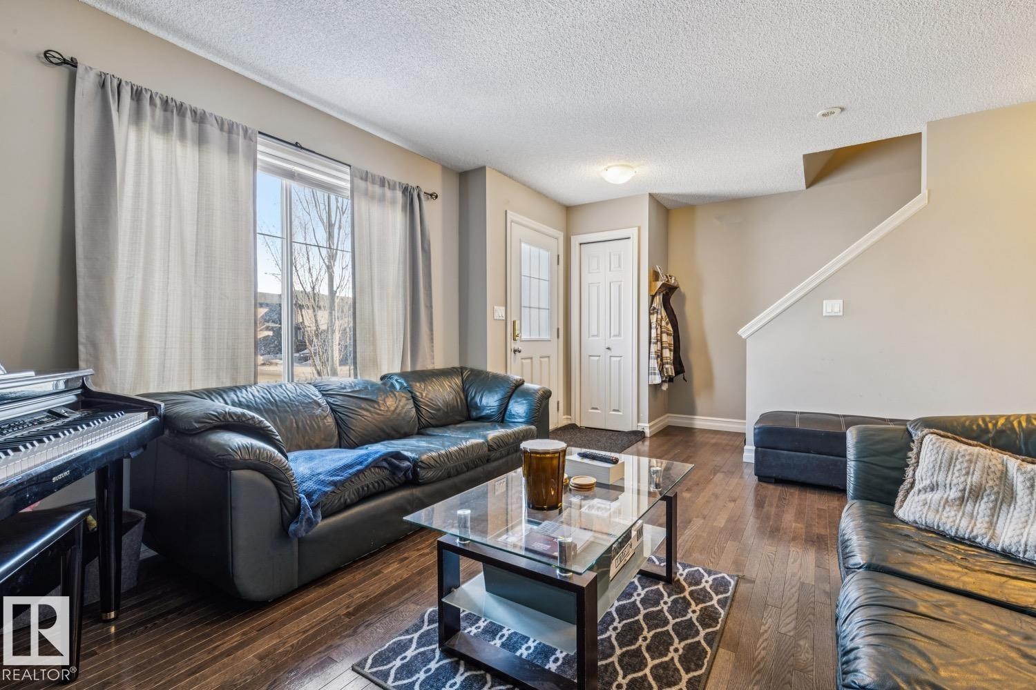 Living area with dark wood-style flooring and a textured ceiling - 5409 3 Avenue, Edmonton, AB - Indoor Photo Showing Living Room